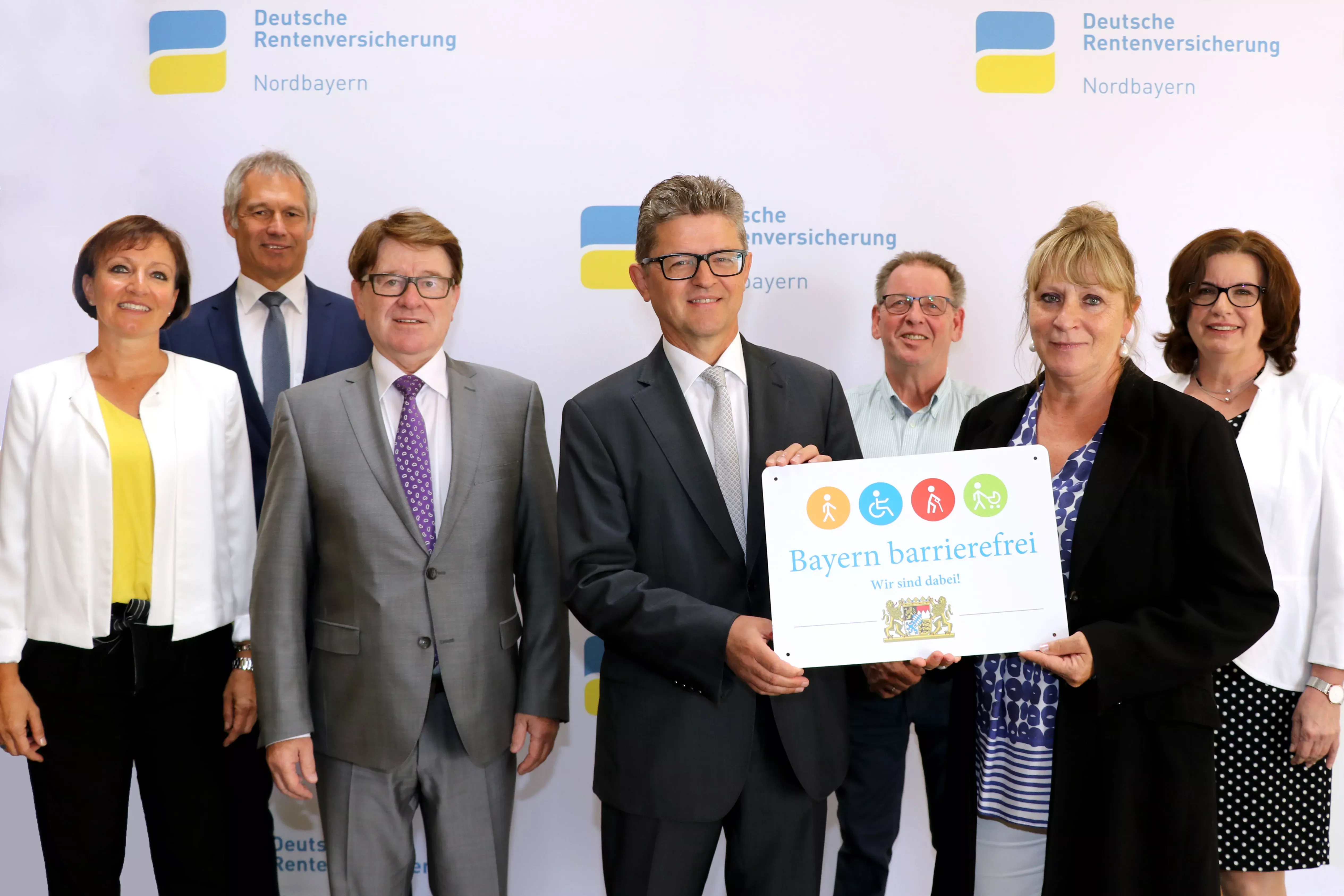 Das Bild zeigt sieben Personen, die an der Verleihung des Signets "Bayern barrierefrei" beteiligt sind.