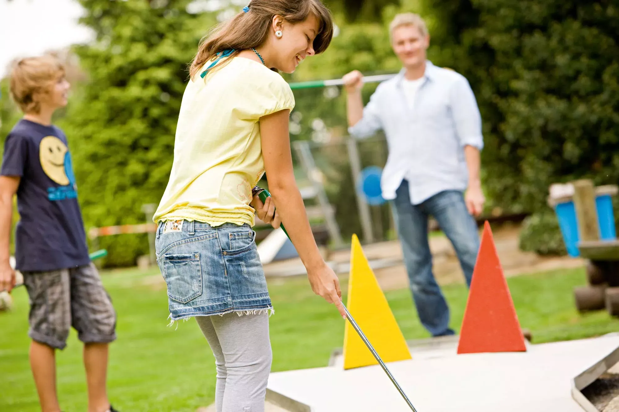 Eine Familie spielt Minigolf.
