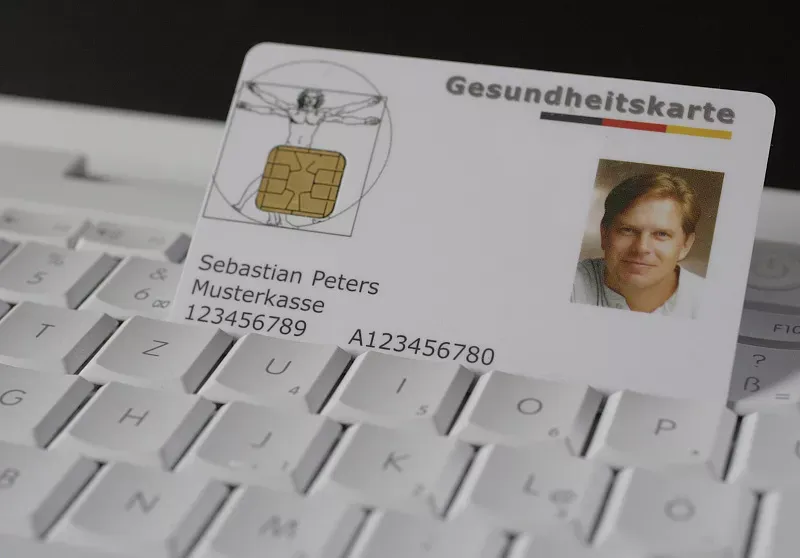 Eine Gesundheitskarte mit Bild steckt in einer Computertastatur. photothek © Ute Grabowsky Eine Gesundheitskarte mit Bild steckt in einer Computertastatur. photothek © Ute Grabowsky