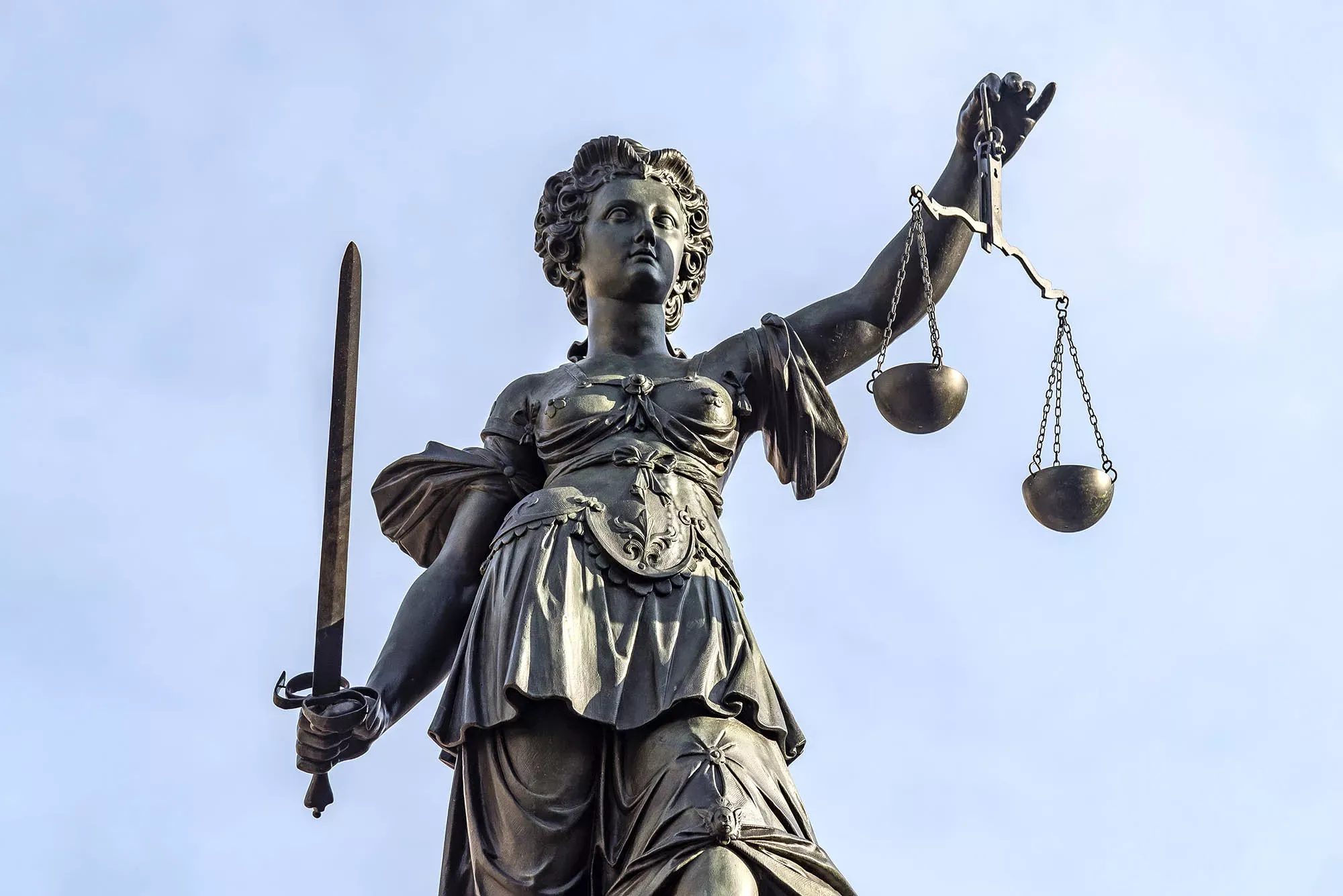 Statue der Justizia aus Bronze vor blauem Himmel. Statue der Justizia aus Bronze vor blauem Himmel.