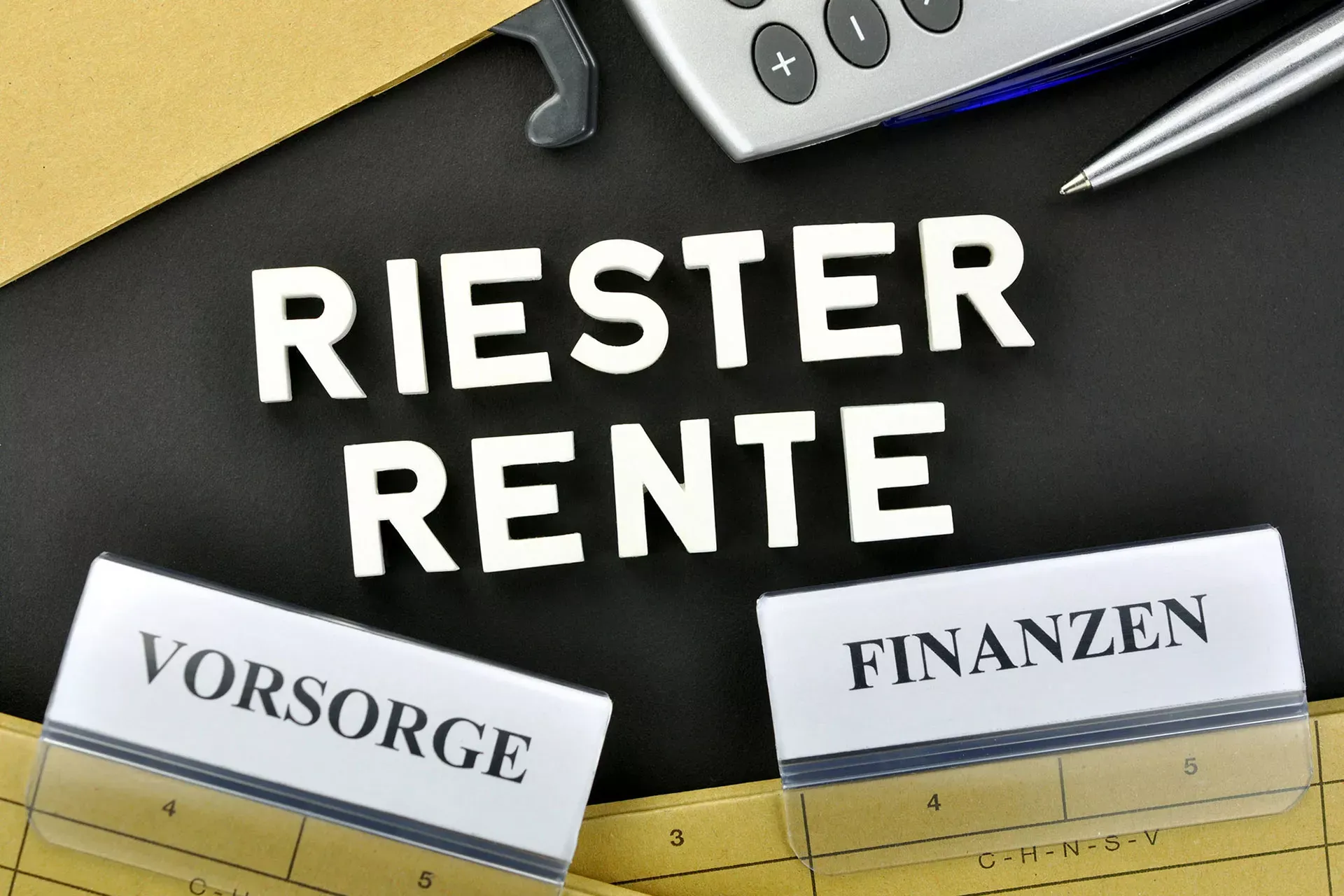 Riester-Rente: Hängeordner mit Reiterschildern Vorsorge und Finanzen sowie Taschenrechner. Riester-Rente: Hängeordner mit Reiterschildern Vorsorge und Finanzen sowie Taschenrechner.