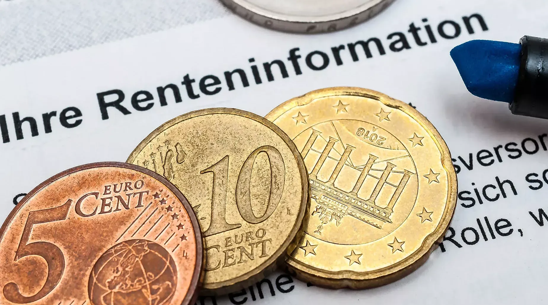 Geldmünzen liegen auf einem Dokument Renteninformation. Geldmünzen liegen auf einem Dokument Renteninformation.