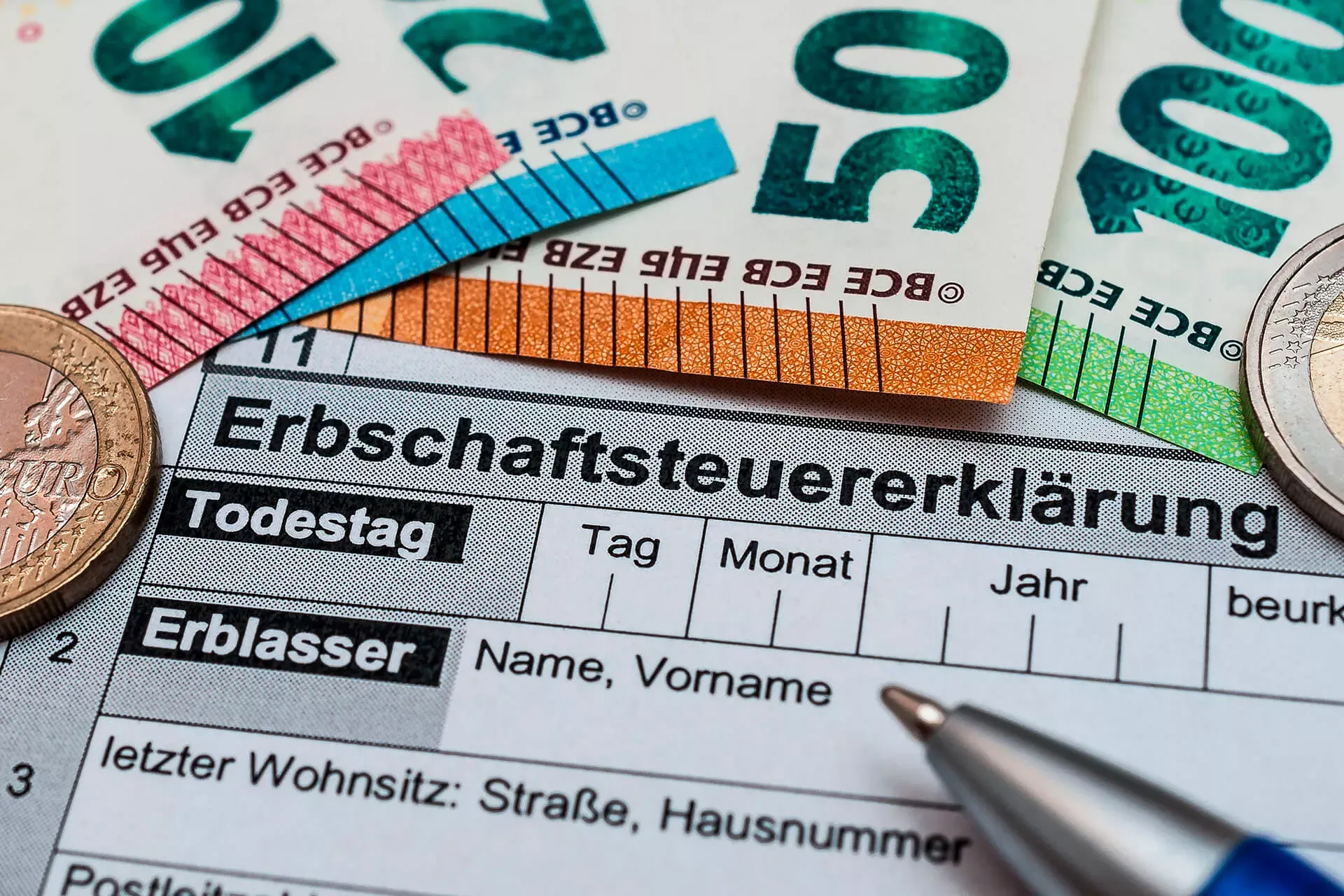 Erbschaftssteuererklärung mit Kugelschreiber, Geldscheinen und Münzen. Erbschaftssteuererklärung mit Kugelschreiber, Geldscheinen und Münzen.