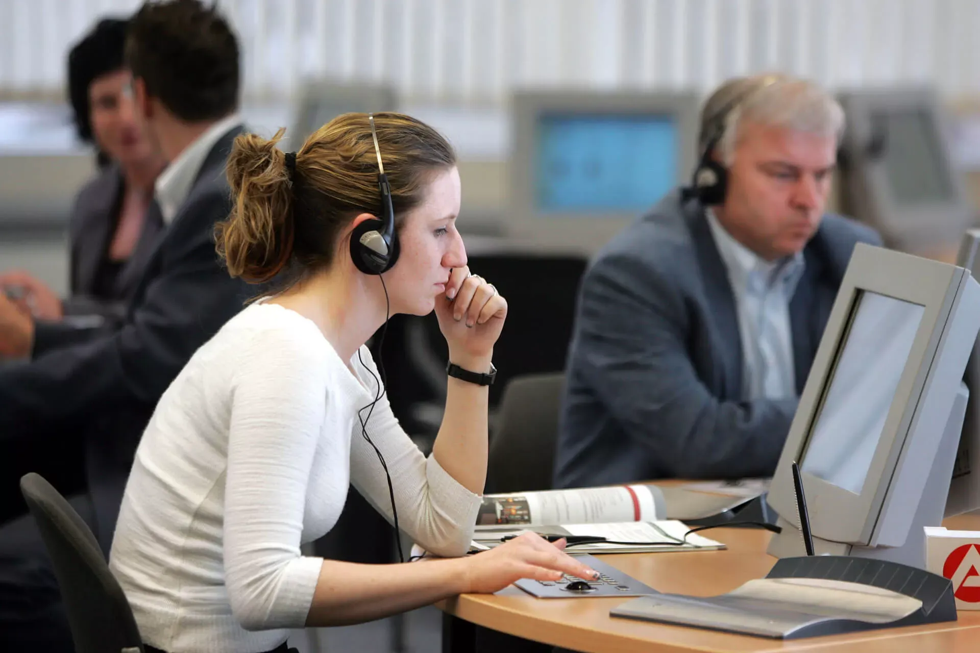 Sachbearbeiterin in der Arbeitsagentur telefoniert mit Headset in einem Großraumbüro. Sachbearbeiterin in der Arbeitsagentur telefoniert mit Headset in einem Großraumbüro.