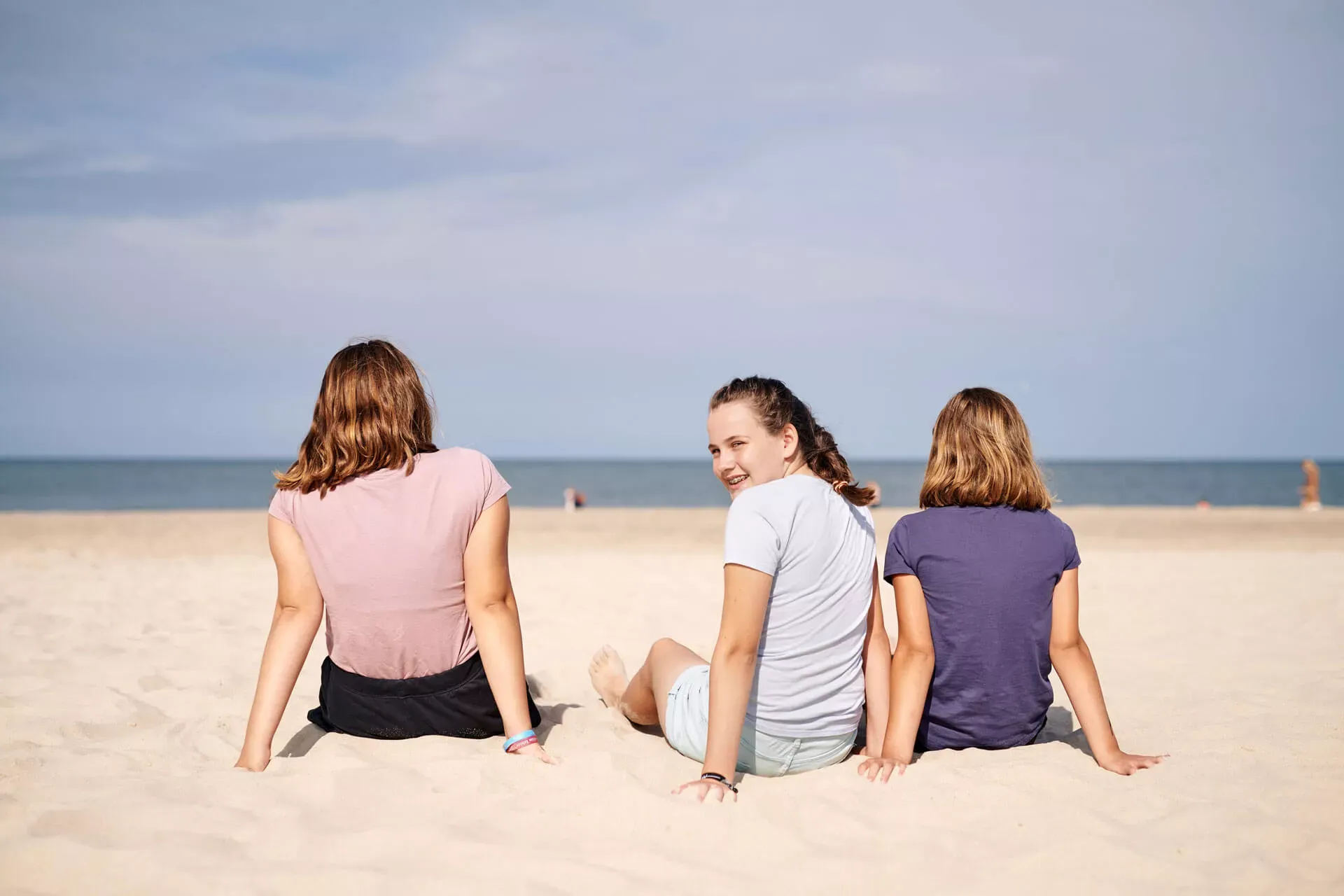 Mädchen im Teenageralter sitzen im Sand am Strand von Sylt. Mädchen im Teenageralter sitzen im Sand am Strand von Sylt.