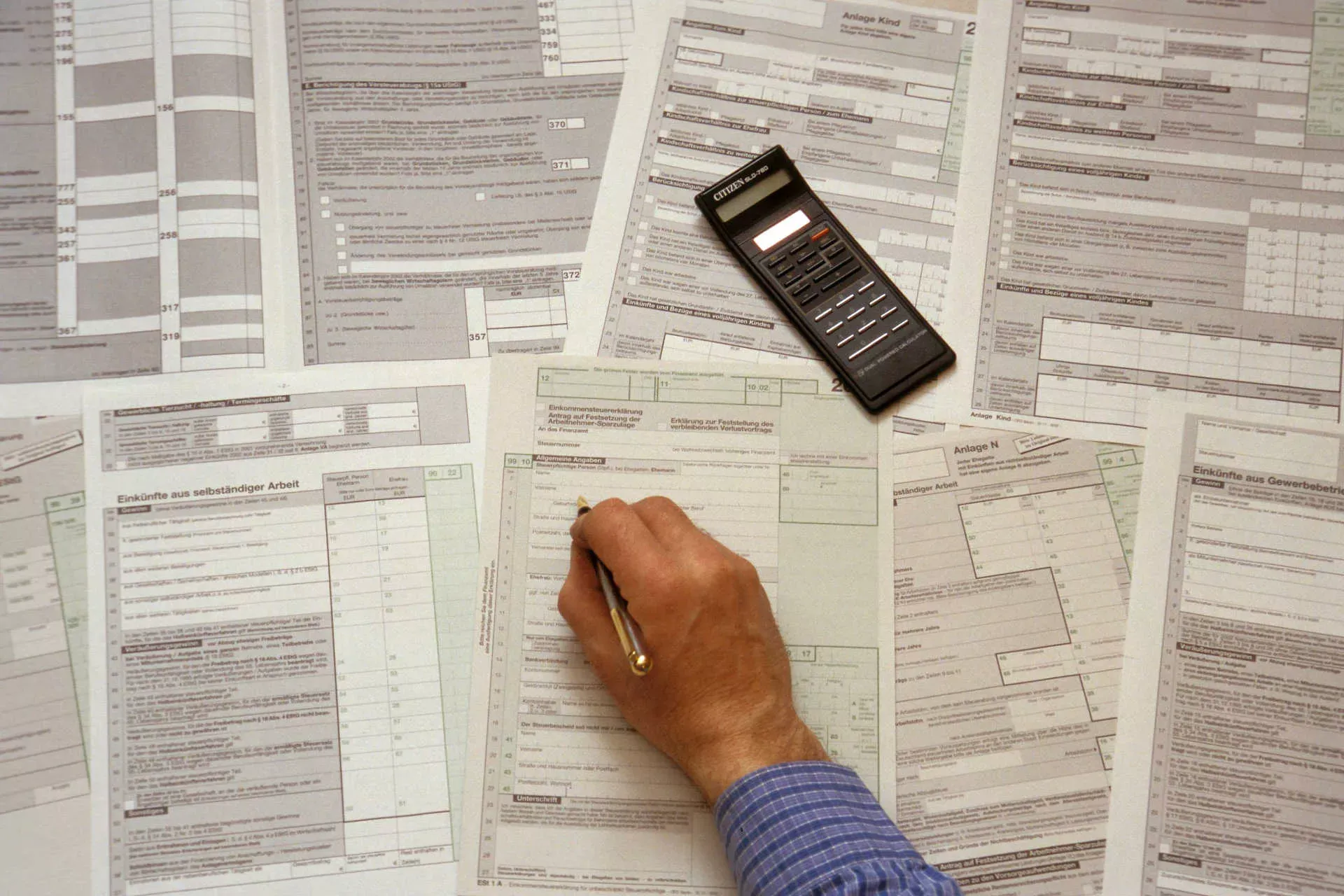 Mann mit Taschenrechner füllt Einkommensteuer-Formulare aus. Bild: IMAGO / Steinach Mann mit Taschenrechner füllt Einkommensteuer-Formulare aus. Bild: IMAGO / Steinach