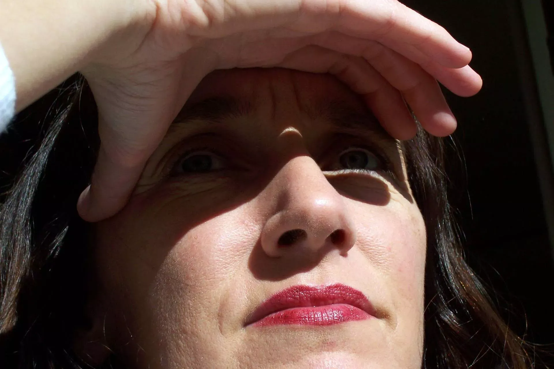 Frau mittleren Alters schützt ihre Augen mit der Hand vor Sonnenlicht. Bild: IMAGO / Dieter Matthes Frau mittleren Alters schützt ihre Augen mit der Hand vor Sonnenlicht. Bild: IMAGO / Dieter Matthes