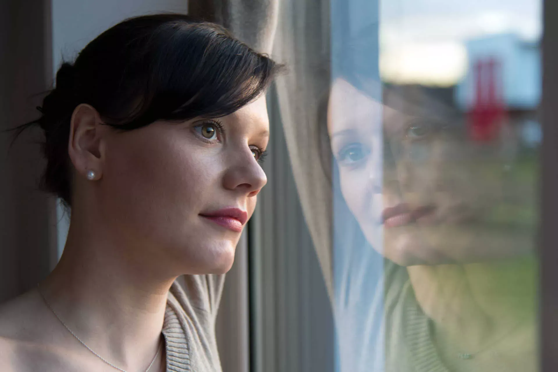 Junge traurige Frau schaut aus dem Fenster. Bild: IMAGO / Andreas Krone Junge traurige Frau schaut aus dem Fenster. Bild: IMAGO / Andreas Krone