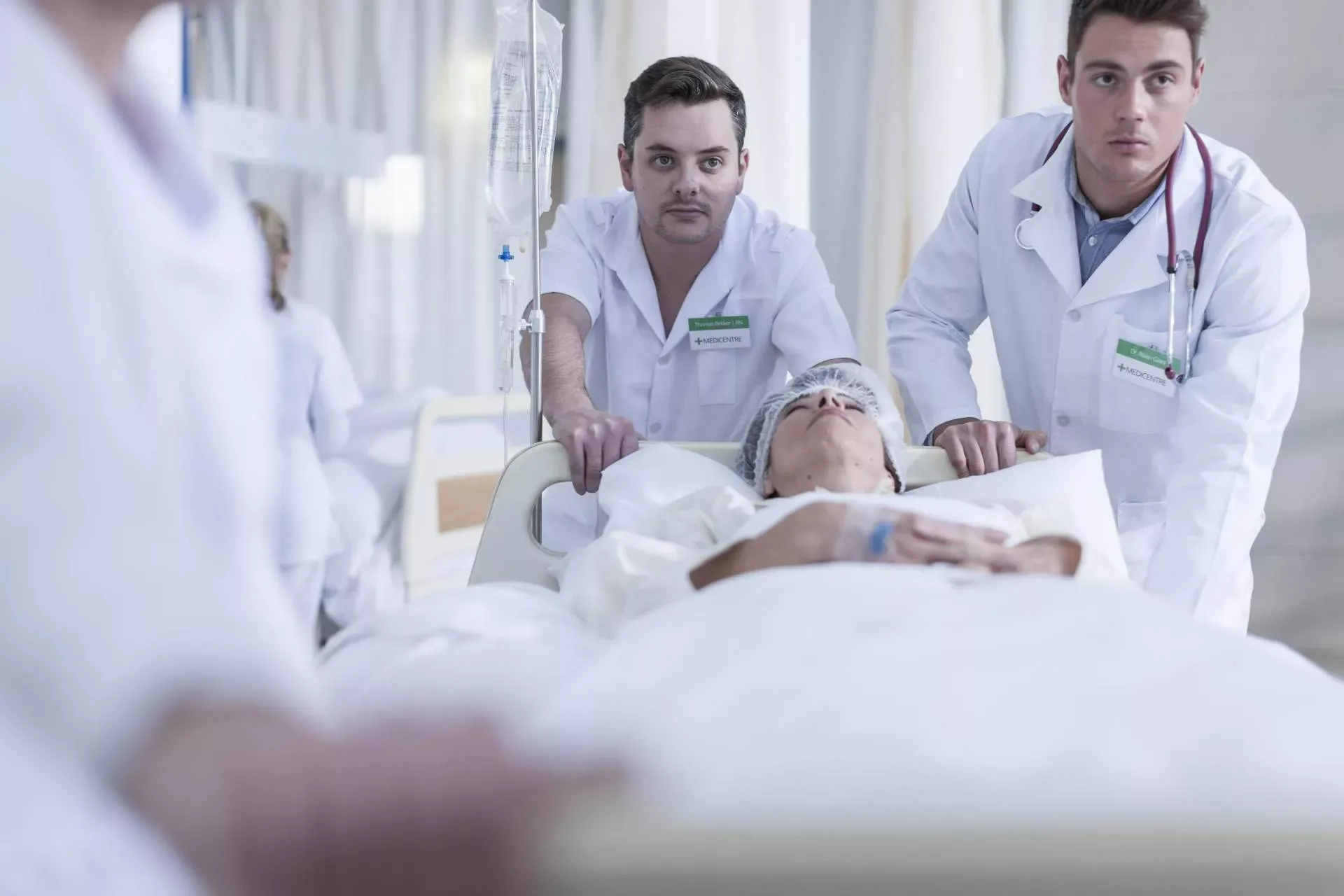 Krankenhausmitarbeiter schieben eine Patientin im Krankenbett durch den Flur. Bild: IMAGO / Westend61 Krankenhausmitarbeiter schieben eine Patientin im Krankenbett durch den Flur. Bild: IMAGO / Westend61