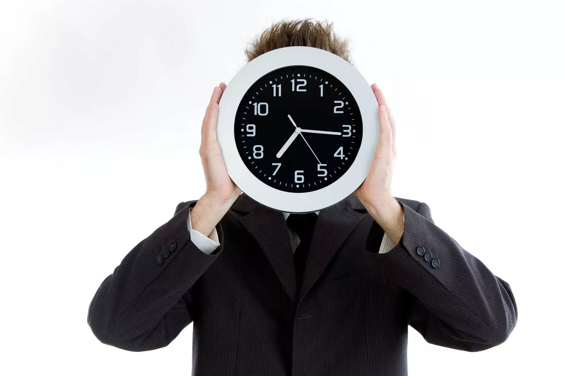 Mann im Businessanzug hält eine Uhr vor sein Gesicht. Bild: IMAGO / blickwinkel / imago stock&people Mann im Businessanzug hält eine Uhr vor sein Gesicht. Bild: IMAGO / blickwinkel / imago stock&people