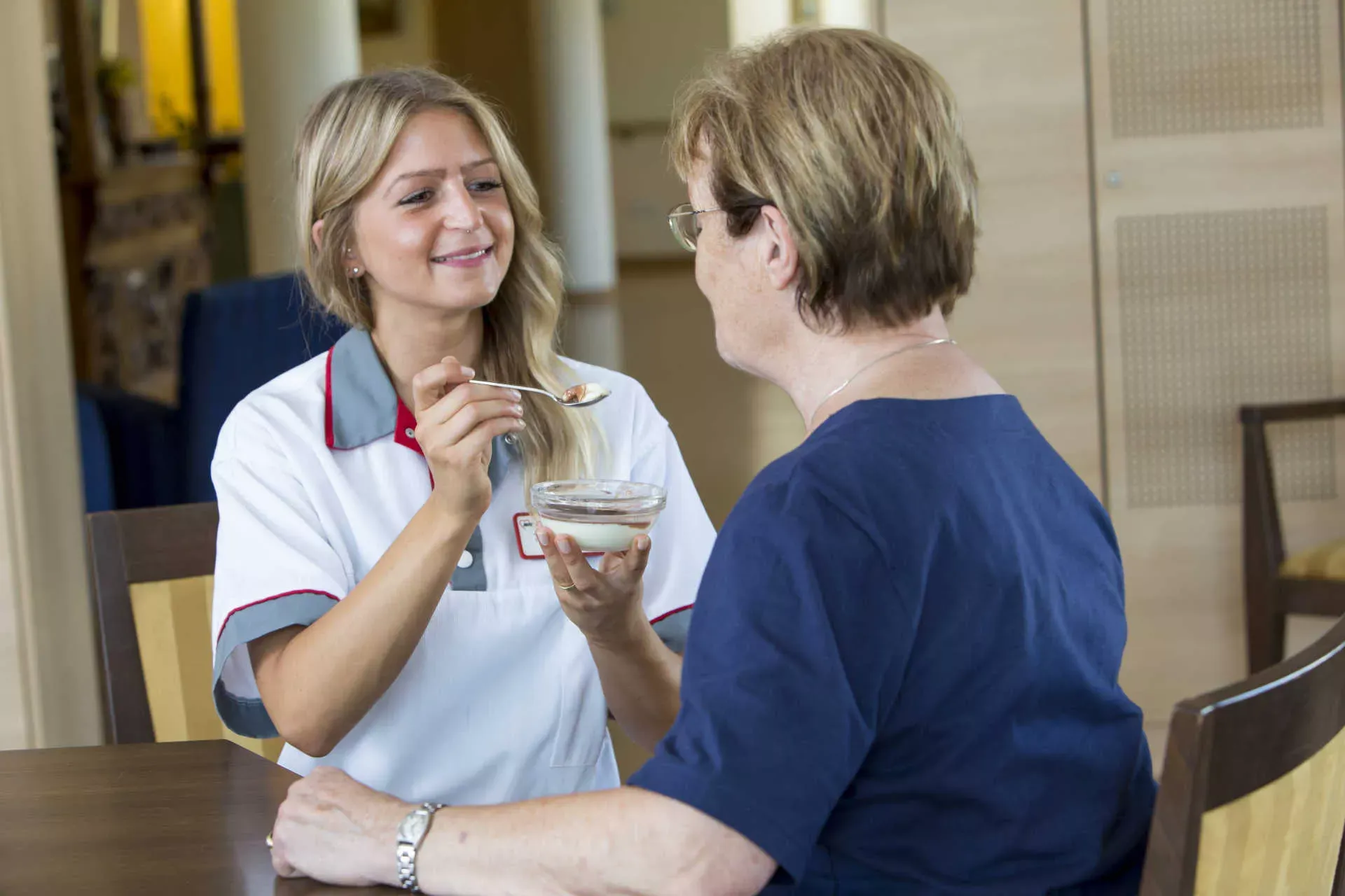 Pflegerin hilft Seniorin im Pflegeheim beim Essen. Bild: IMAGO / Jochen Tack / imago stock&people Pflegerin hilft Seniorin im Pflegeheim beim Essen. Bild: IMAGO / Jochen Tack / imago stock&people