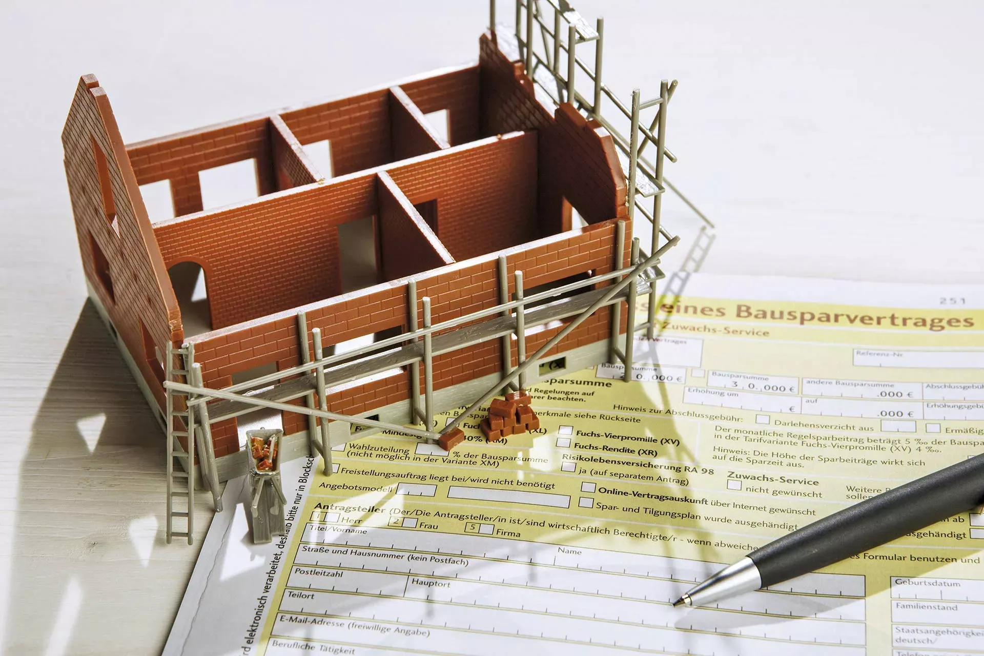 Hausmodell Rohbau steht auf einem Bausparvertrag. – Bild: IMAGO / allOver-MEV / imago stock&people Hausmodell Rohbau steht auf einem Bausparvertrag. – Bild: IMAGO / allOver-MEV / imago stock&people