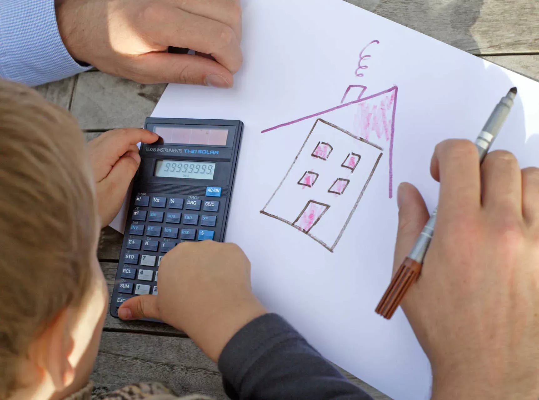Vater und Sohn sitzen über Hauszeichnung mit Stift und Taschenrechner. Bild: IMAGO / photothek / Ute Grabowsky Vater und Sohn sitzen über Hauszeichnung mit Stift und Taschenrechner. Bild: IMAGO / photothek / Ute Grabowsky