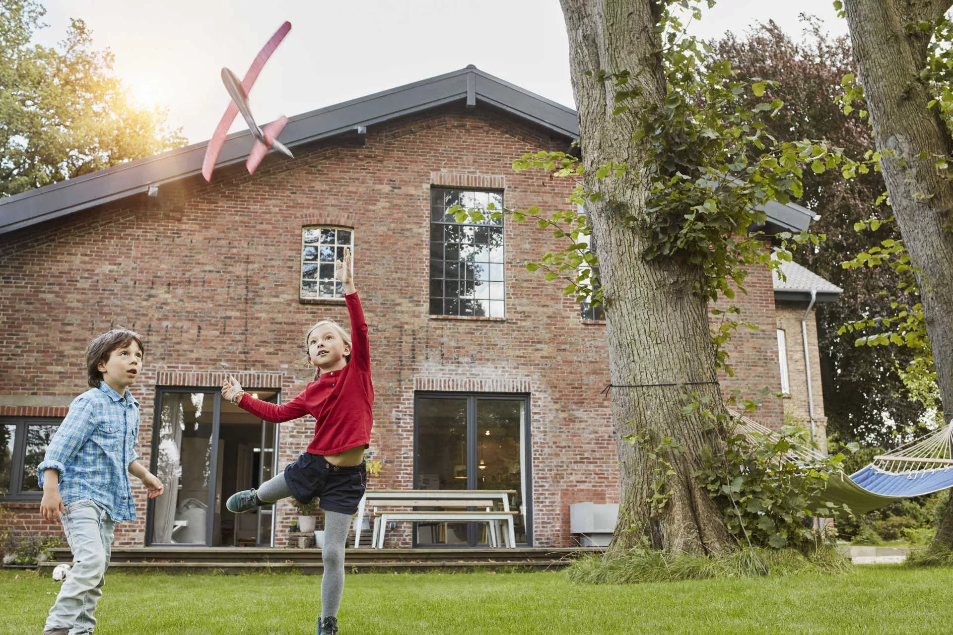 Zwei Kinder spielen im Garten vor ihrem Haus. Bild: IMAGO / Westend61 / Roger Richter Zwei Kinder spielen im Garten vor ihrem Haus. Bild: IMAGO / Westend61 / Roger Richter