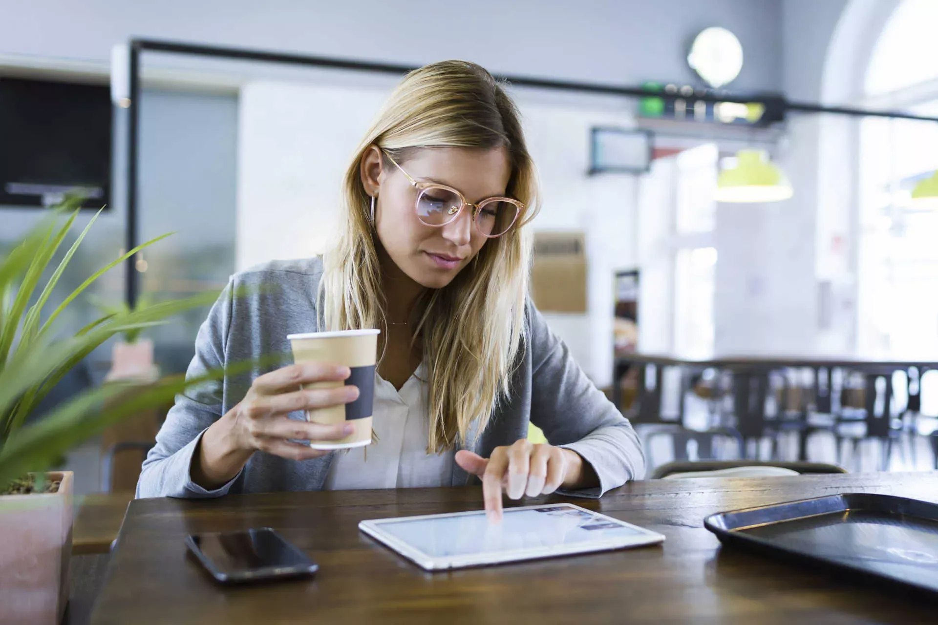 Junge Frau arbeitet in Cafeteria an ihrem Tablet. Bild: IMAGO / Westend61 Junge Frau arbeitet in Cafeteria an ihrem Tablet. Bild: IMAGO / Westend61