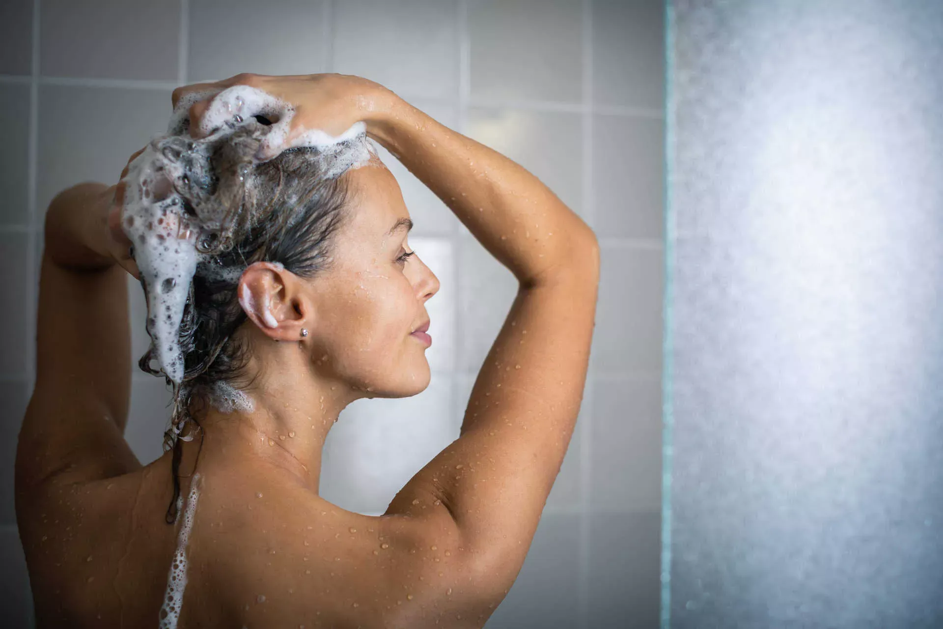 Junge Frau steht unter der Dusche und shampooniert sich die Haare. Bild: IMAGO / Panthermedia / Lightpoet Junge Frau steht unter der Dusche und shampooniert sich die Haare. Bild: IMAGO / Panthermedia / Lightpoet
