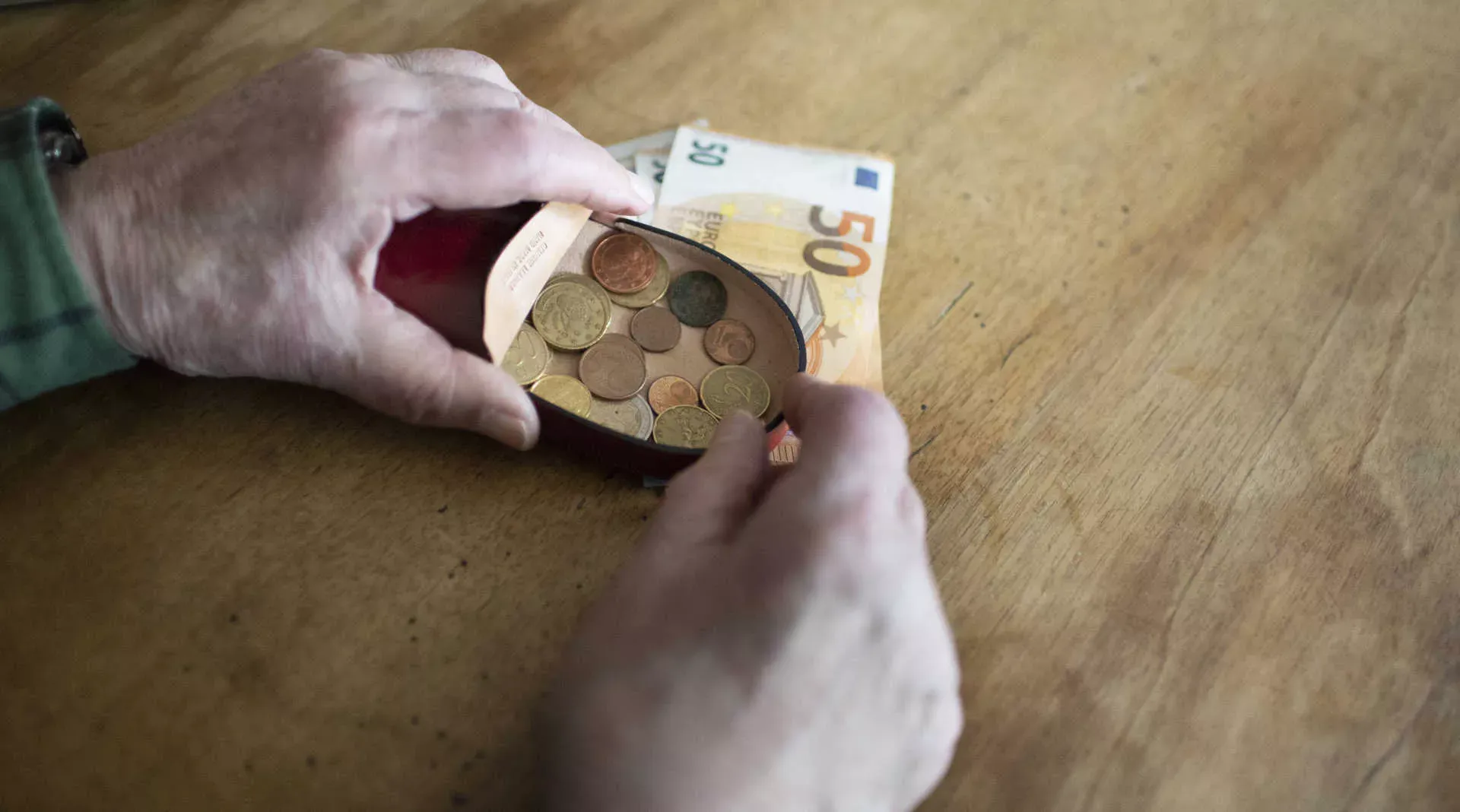 Alte Hände mit einer Schüttelbörse mit Geldmünzen, auf dem Tisch liegen 50-Euro-Scheine. Bild: IMAGO / photothek / Ute Grabowsky Alte Hände mit einer Schüttelbörse mit Geldmünzen, auf dem Tisch liegen 50-Euro-Scheine. Bild: IMAGO / photothek / Ute Grabowsky