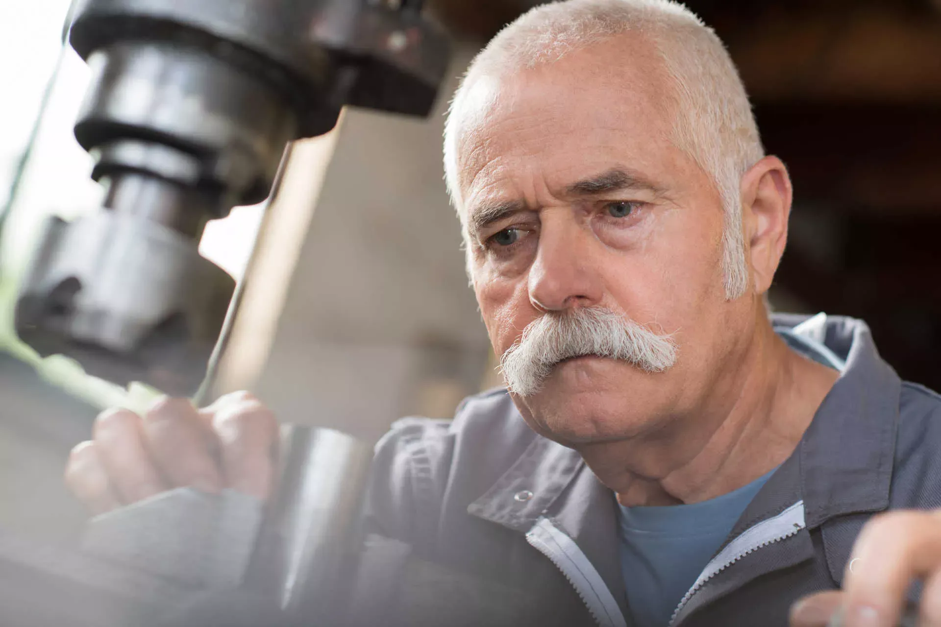 Älterer Handwerker arbeitet in Metall-Werkstatt an Maschine. Bild: IMAGO / agefotostock / photography33 Älterer Handwerker arbeitet in Metall-Werkstatt an Maschine. Bild: IMAGO / agefotostock / photography33