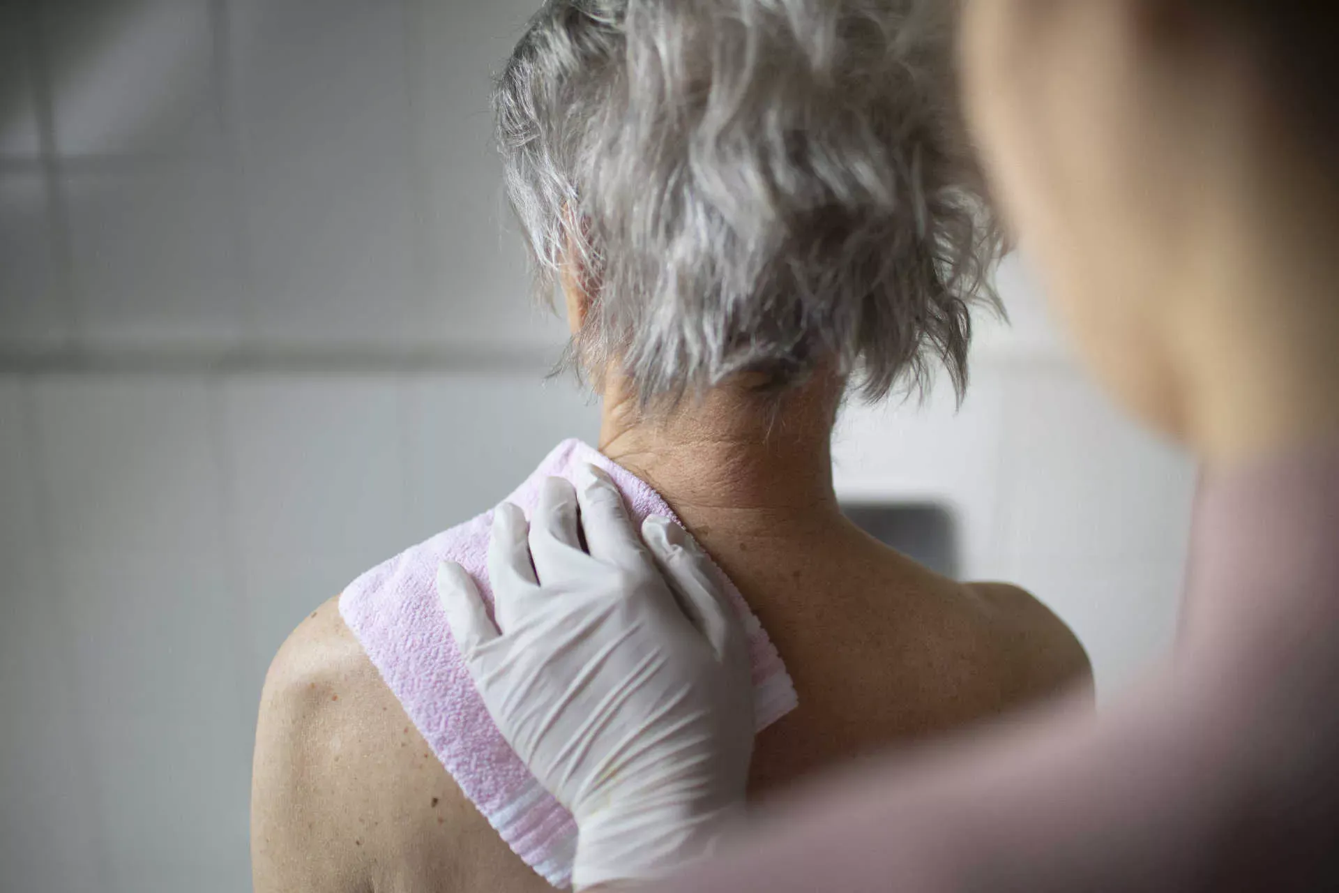 Seniorin wird von Pflegerin der Rücken mit einem Waschlappen gewaschen. Bild: IMAGO / photothek / Ute Grabowsky Seniorin wird von Pflegerin der Rücken mit einem Waschlappen gewaschen. Bild: IMAGO / photothek / Ute Grabowsky