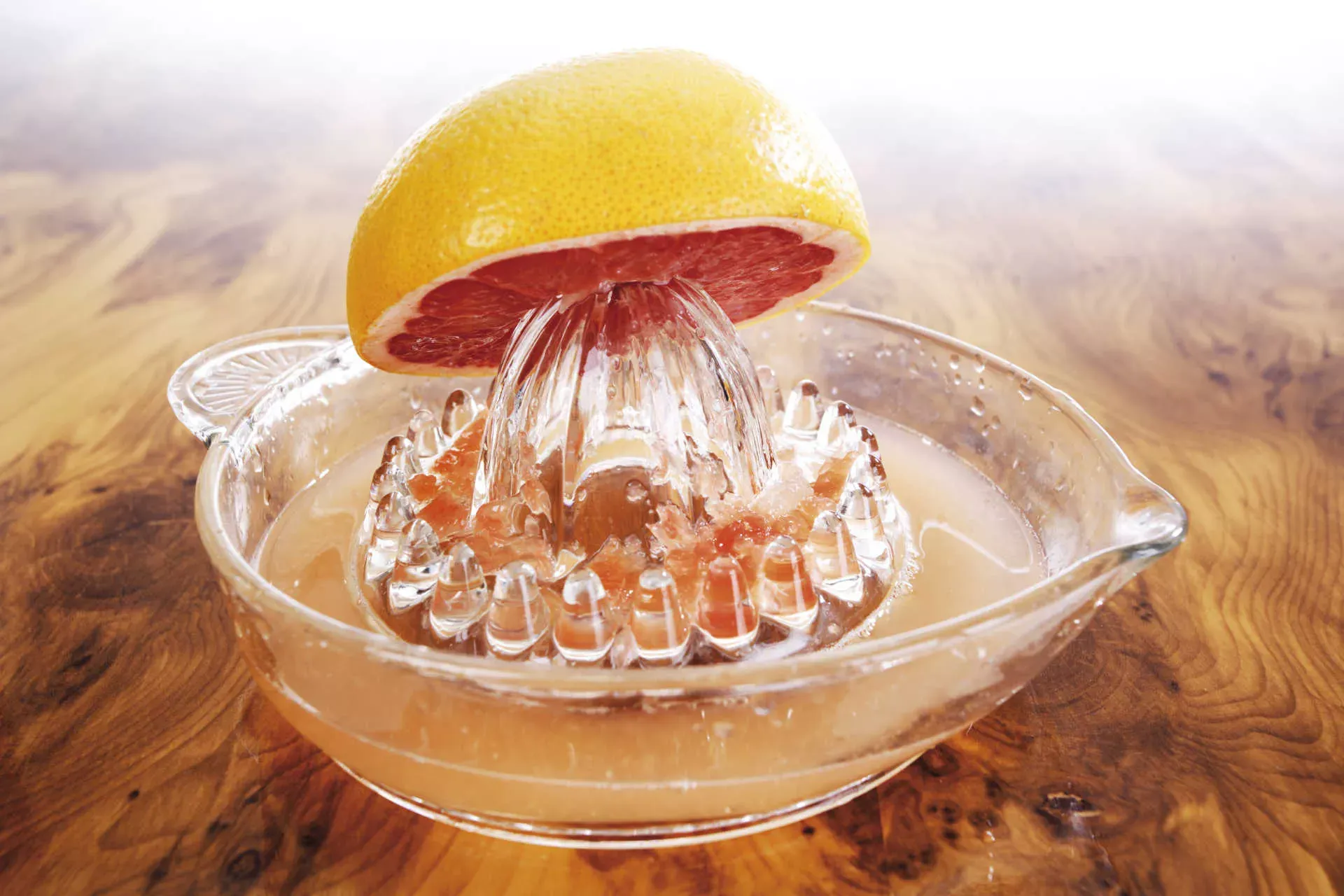 Halbe Grapefruit auf Saftpresse aus Glas. Bild: IMAGO / Shotshop / CSH Halbe Grapefruit auf Saftpresse aus Glas. Bild: IMAGO / Shotshop / CSH