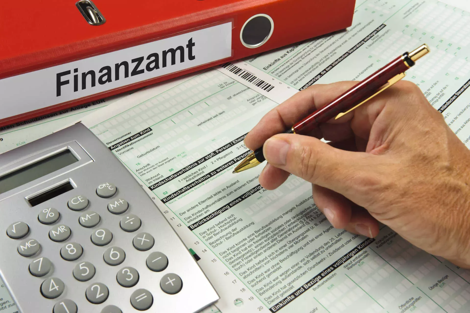Hand füllt Steuerformular mit Kugelschreiber aus, Taschenrechner und Ordner Finanzamt. Bild: IMAGO / Shotshop / Wolfilser Hand füllt Steuerformular mit Kugelschreiber aus, Taschenrechner und Ordner Finanzamt. Bild: IMAGO / Shotshop / Wolfilser