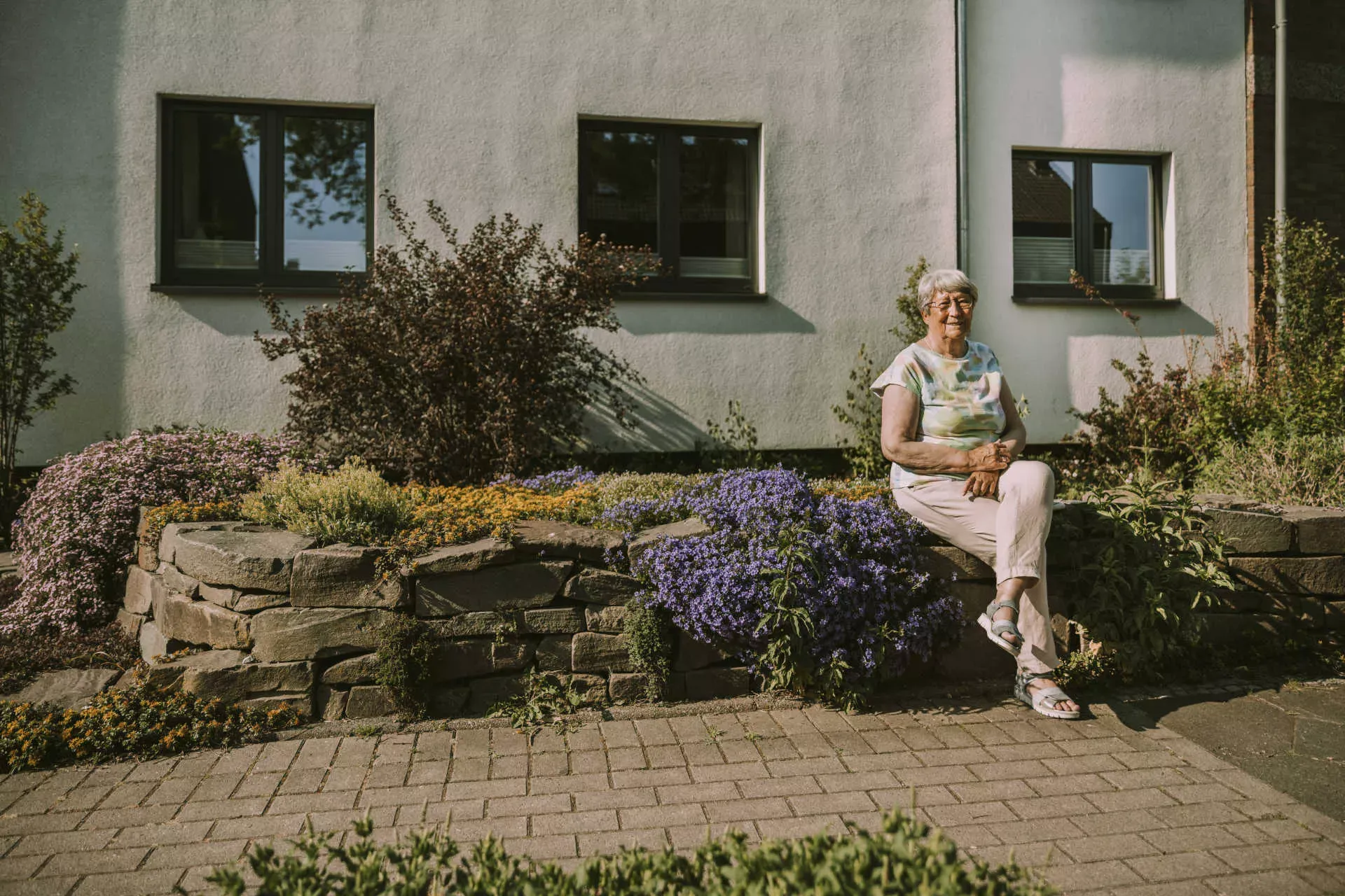 Seniorin sitzt vor ihrem Haus in der Sonne. Bild: IMAGO / Westend61 / Mareen Fischinger Seniorin sitzt vor ihrem Haus in der Sonne. Bild: IMAGO / Westend61 / Mareen Fischinger