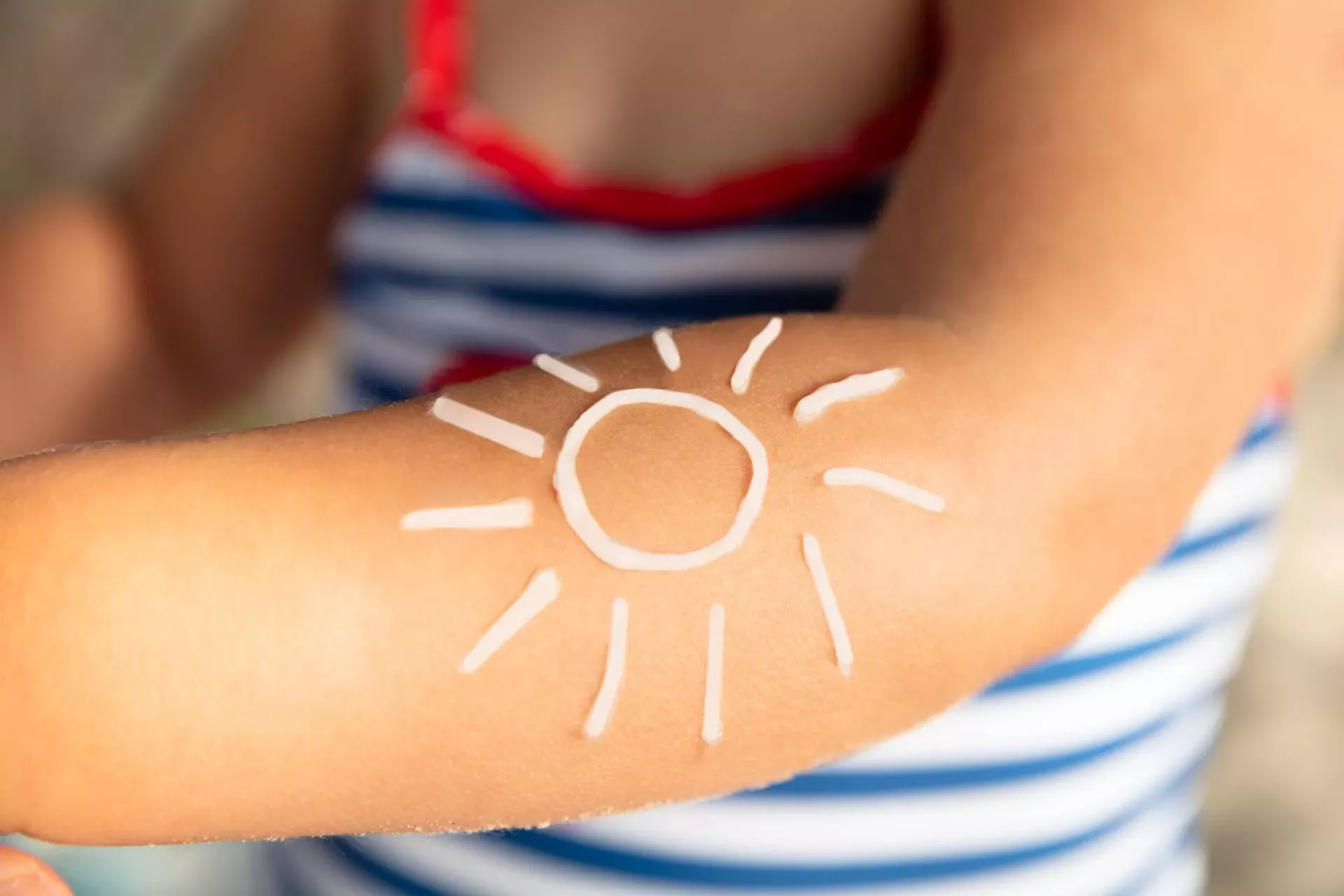 Sonnenmilch verteilt in Form einer Sonne auf dem Arm eines Mädchens. Bild: IMAGO / Panthermedia Sonnenmilch verteilt in Form einer Sonne auf dem Arm eines Mädchens. Bild: IMAGO / Panthermedia