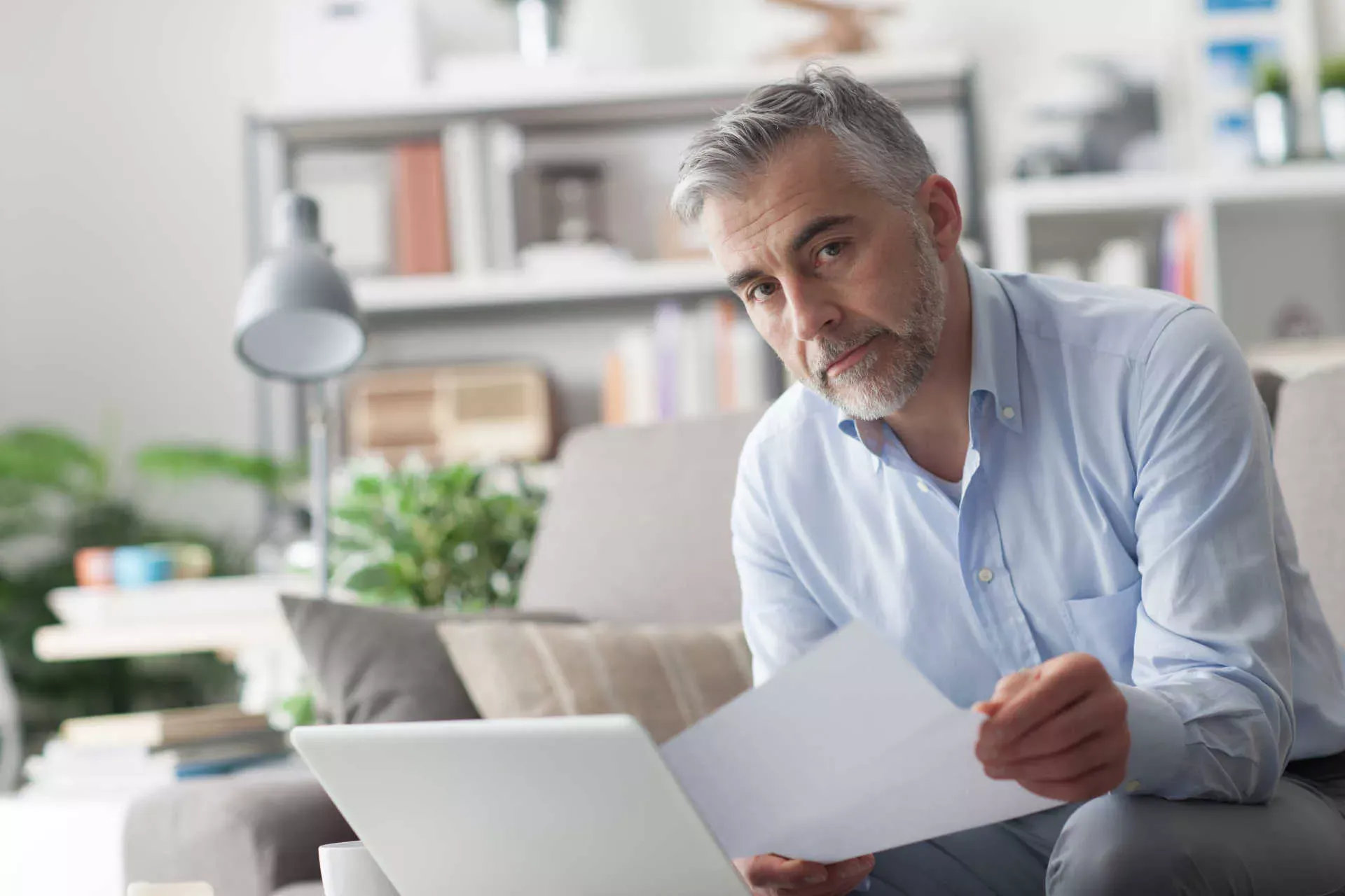 Mann sitzt auf dem Sofa und liest ein Dokument. Bild: IMAGO / agefotostock / stokkete Mann sitzt auf dem Sofa und liest ein Dokument. Bild: IMAGO / agefotostock / stokkete