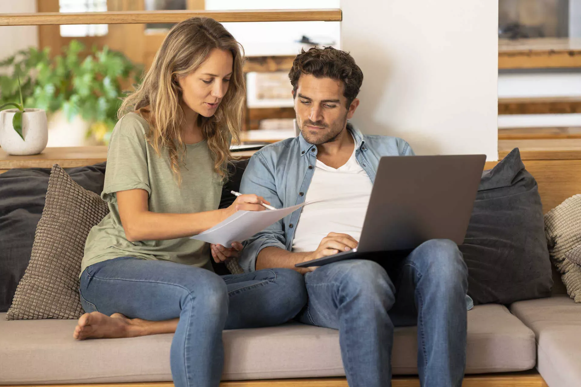 Paar sitzt auf der Couch mit Papieren und Notebook. Bild: IMAGO / Westend61 / Steve Brookland Paar sitzt auf der Couch mit Papieren und Notebook. Bild: IMAGO / Westend61 / Steve Brookland