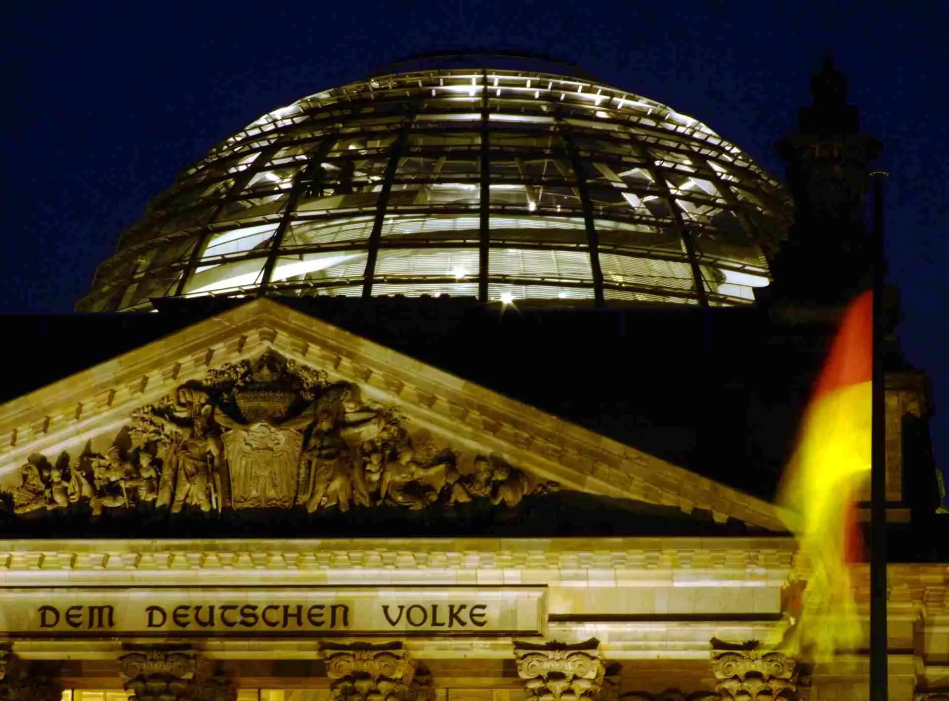 Kuppel des Reichstagsgebäudes in Berlin abendlich beleuchtet mit deutscher Flagge im Vordergrund. Bild: IMAGO / Panthermedia Kuppel des Reichstagsgebäudes in Berlin abendlich beleuchtet mit deutscher Flagge im Vordergrund. Bild: IMAGO / Panthermedia