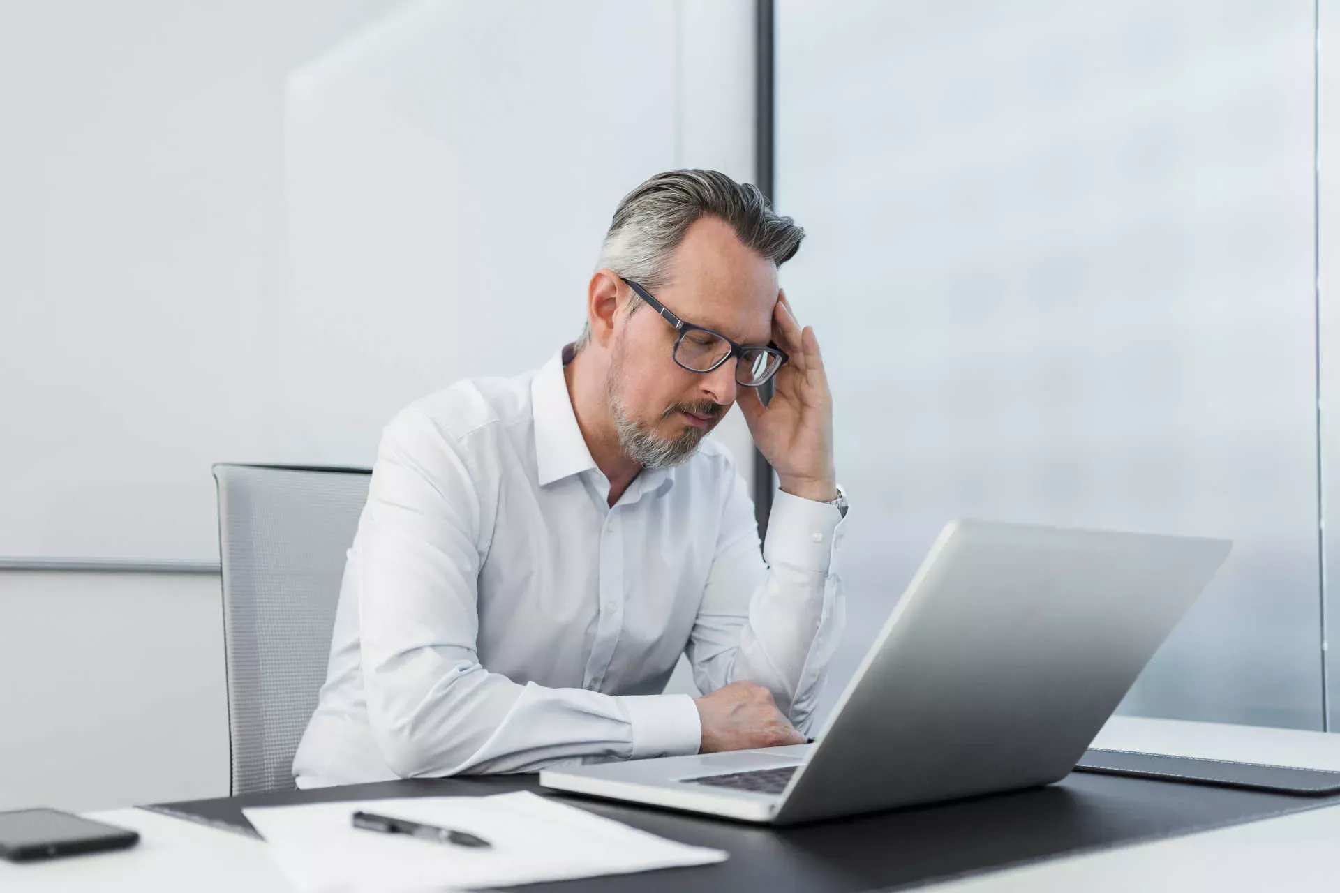 Mann sitzt am Schreibtisch vor Notebook und hält sich die Finger an die schmerzende Schläfe mit geschlossenen Augen. Bild: IMAGO / Westend61 / Daniel Ingold Mann sitzt am Schreibtisch vor Notebook und hält sich die Finger an die schmerzende Schläfe mit geschlossenen Augen. Bild: IMAGO / Westend61 / Daniel Ingold
