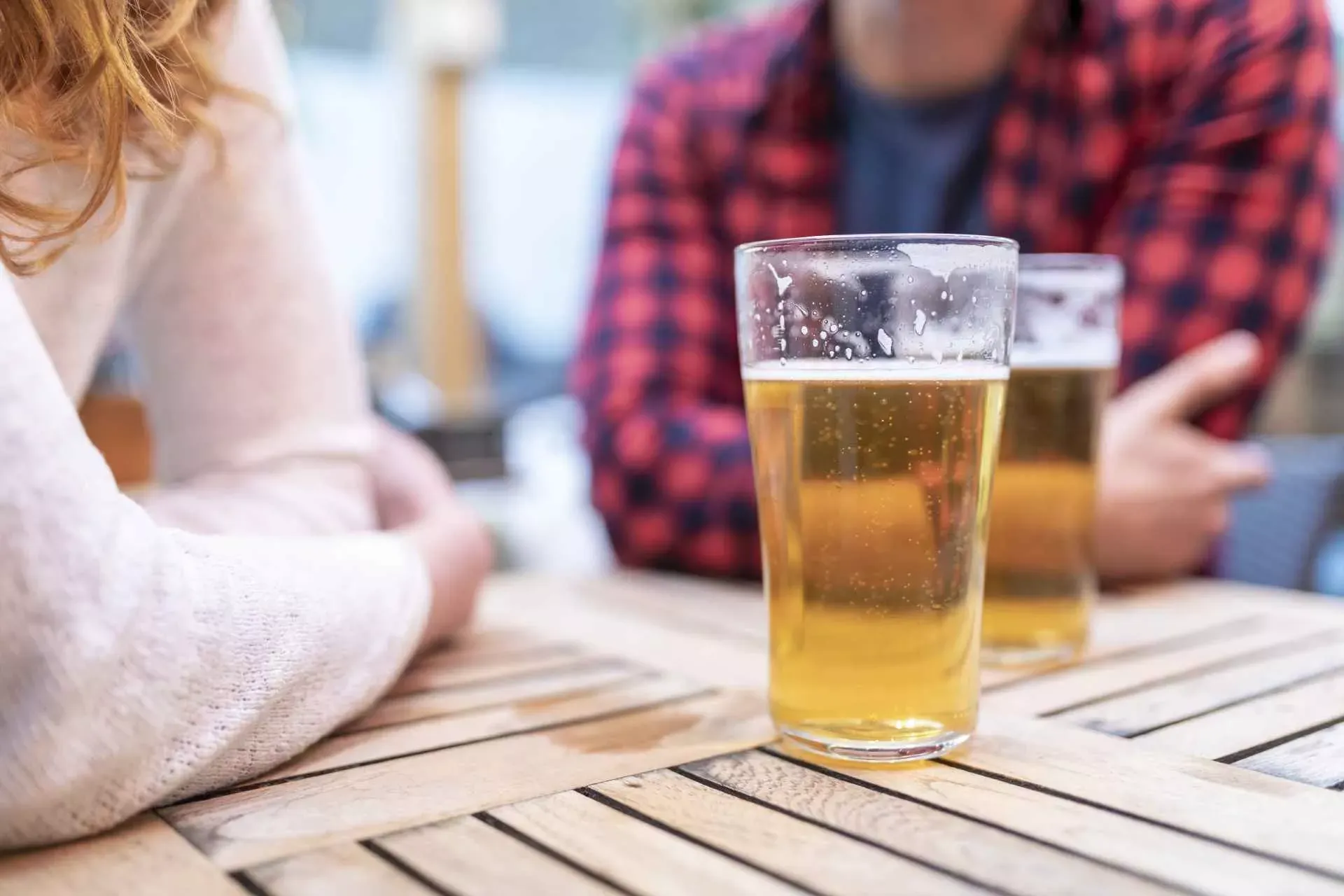 Zwei Menschen an einem Tisch im Biergarten mit Biergläsern. Bild: IMAGO / Westend61 Zwei Menschen an einem Tisch im Biergarten mit Biergläsern. Bild: IMAGO / Westend61
