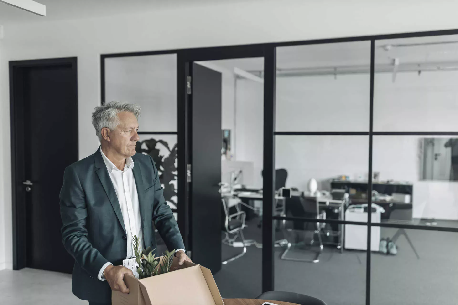 Gekündigter Mann mit mittleren Alter steht mit einem Karton im Büro. Bild: IMAGO / Westend61 / Gustafsson Gekündigter Mann mit mittleren Alter steht mit einem Karton im Büro. Bild: IMAGO / Westend61 / Gustafsson
