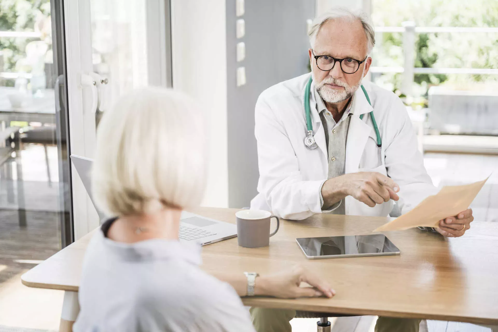 Arzt hält Unterlagen in der Hand und spricht mit Patientin im Rentenalter. Bild: IMAGO / Westend61 / Uwe Umstätter Arzt hält Unterlagen in der Hand und spricht mit Patientin im Rentenalter. Bild: IMAGO / Westend61 / Uwe Umstätter