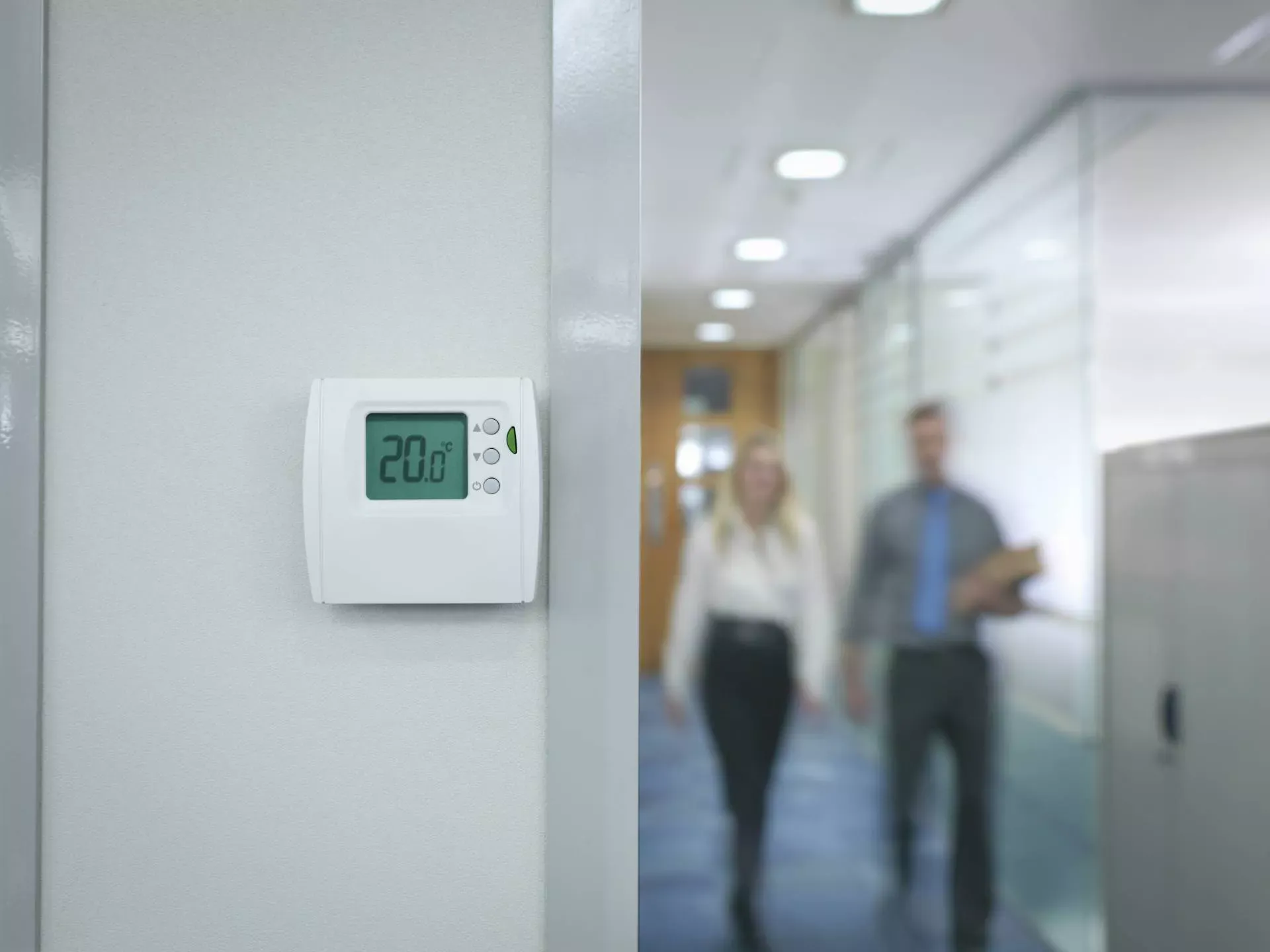 Zwei Büoangestellte gehen durch einen Flur mit Thermostat an der Wand. (Bild: IMAGO / Image Source) Zwei Büoangestellte gehen durch einen Flur mit Thermostat an der Wand. (Bild: IMAGO / Image Source)