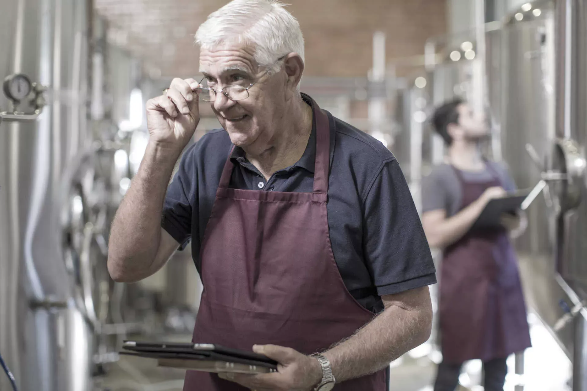 Mann im Rentenalter steht mit Arbeitsschürze in einer Brauerei. Bild: IMAGO / Image Source / zero creatives Mann im Rentenalter steht mit Arbeitsschürze in einer Brauerei. Bild: IMAGO / Image Source / zero creatives