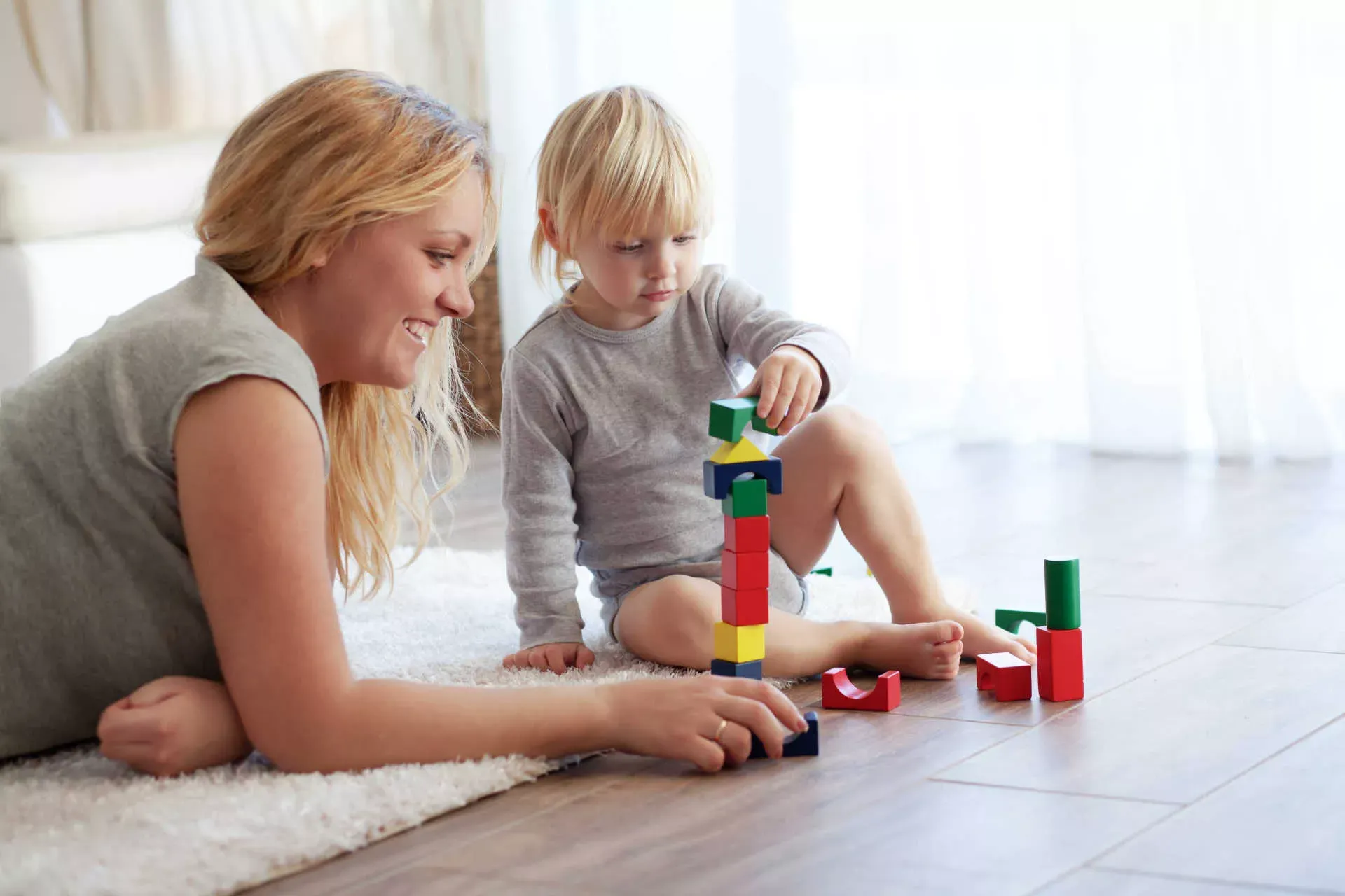 Mutter und Kind spielen auf dem Boden mit Bauklötzen. Bild: IMAGO / YAY Images / alenkasm Mutter und Kind spielen auf dem Boden mit Bauklötzen. Bild: IMAGO / YAY Images / alenkasm