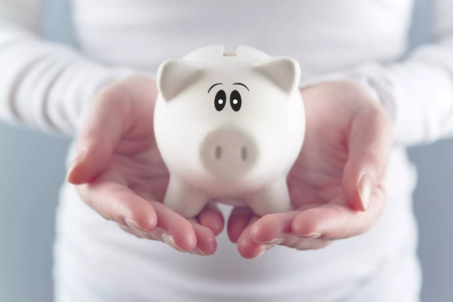 Frauenhände halten ein weißes Sparschwein. Bild: IMAGO / agefotostock / stefanovicigor Frauenhände halten ein weißes Sparschwein. Bild: IMAGO / agefotostock / stefanovicigor