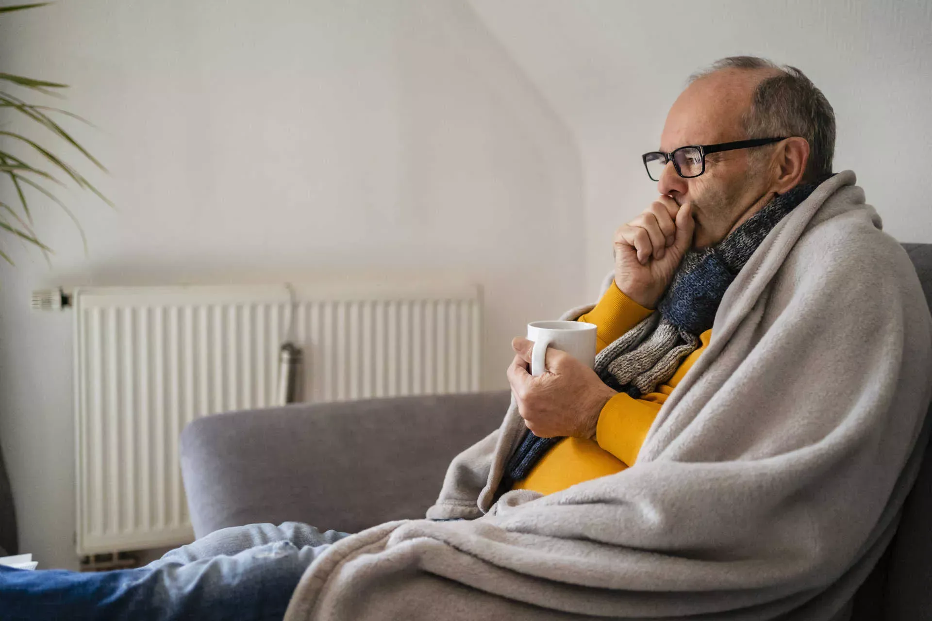 Älterer Mann sitzt hustend mit Decke und Tasse auf dem Sofa. Bild: IMAGO / Westend61 / Daniel Ingold Älterer Mann sitzt hustend mit Decke und Tasse auf dem Sofa. Bild: IMAGO / Westend61 / Daniel Ingold