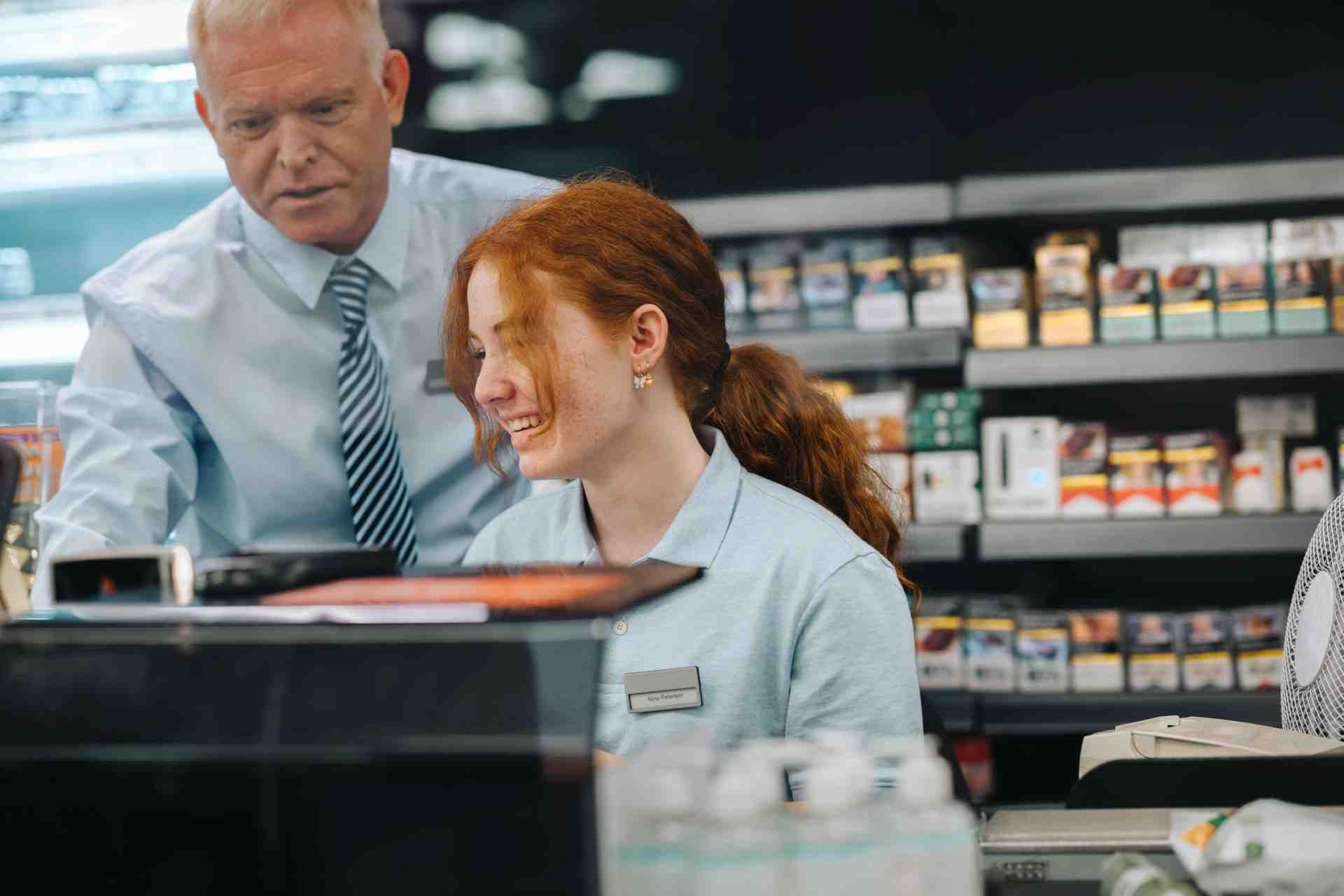 Junge Frau wird an der Supermarktkasse eingearbeitet Junge Frau wird an der Supermarktkasse eingearbeitet