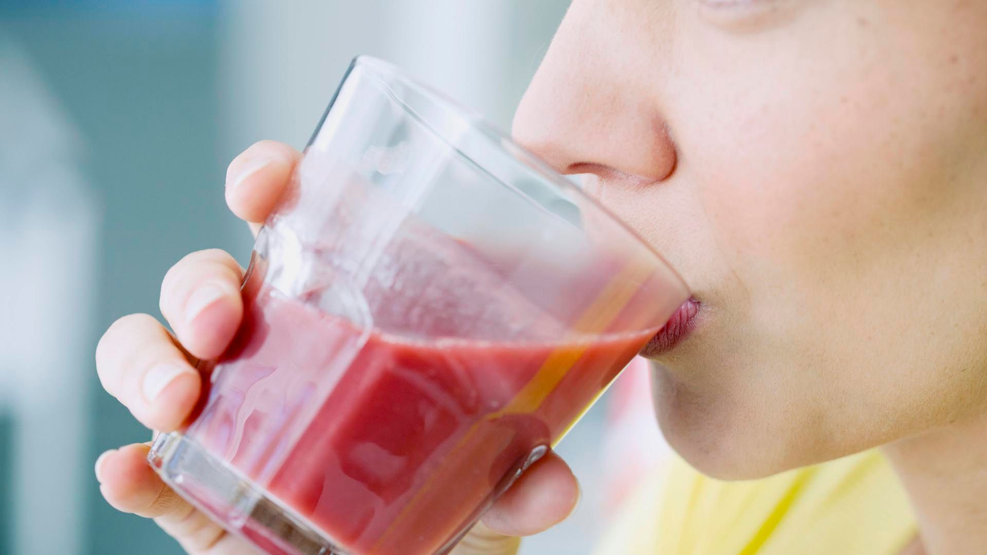 Junge Frau trinkt Saft aus einem Glas Junge Frau trinkt Saft aus einem Glas