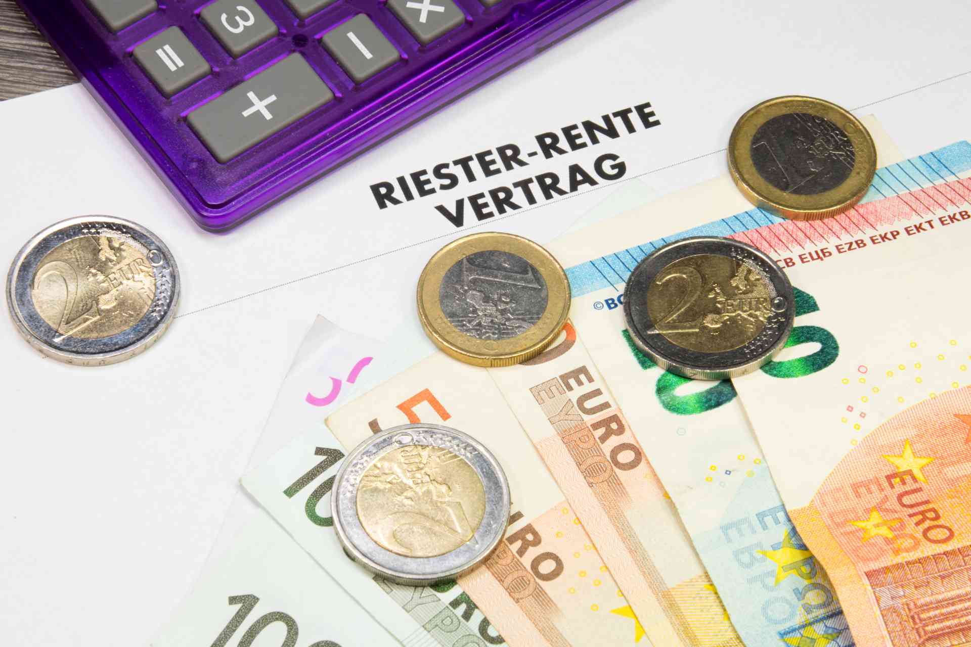 Riester-Vertrag, Geldscheine, Münzen und ein Taschenrechner Riester-Vertrag, Geldscheine, Münzen und ein Taschenrechner