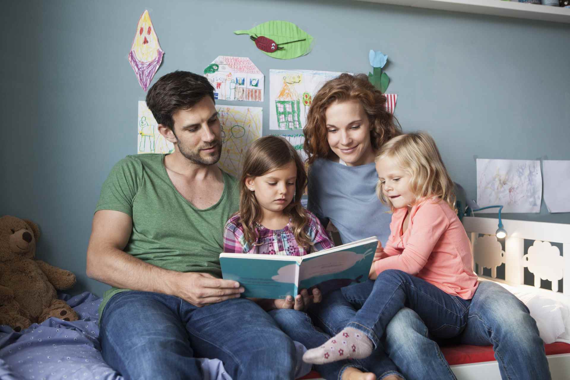 Junge Familie liest gemeinsam ein Bilderbuch. Junge Familie liest gemeinsam ein Bilderbuch.
