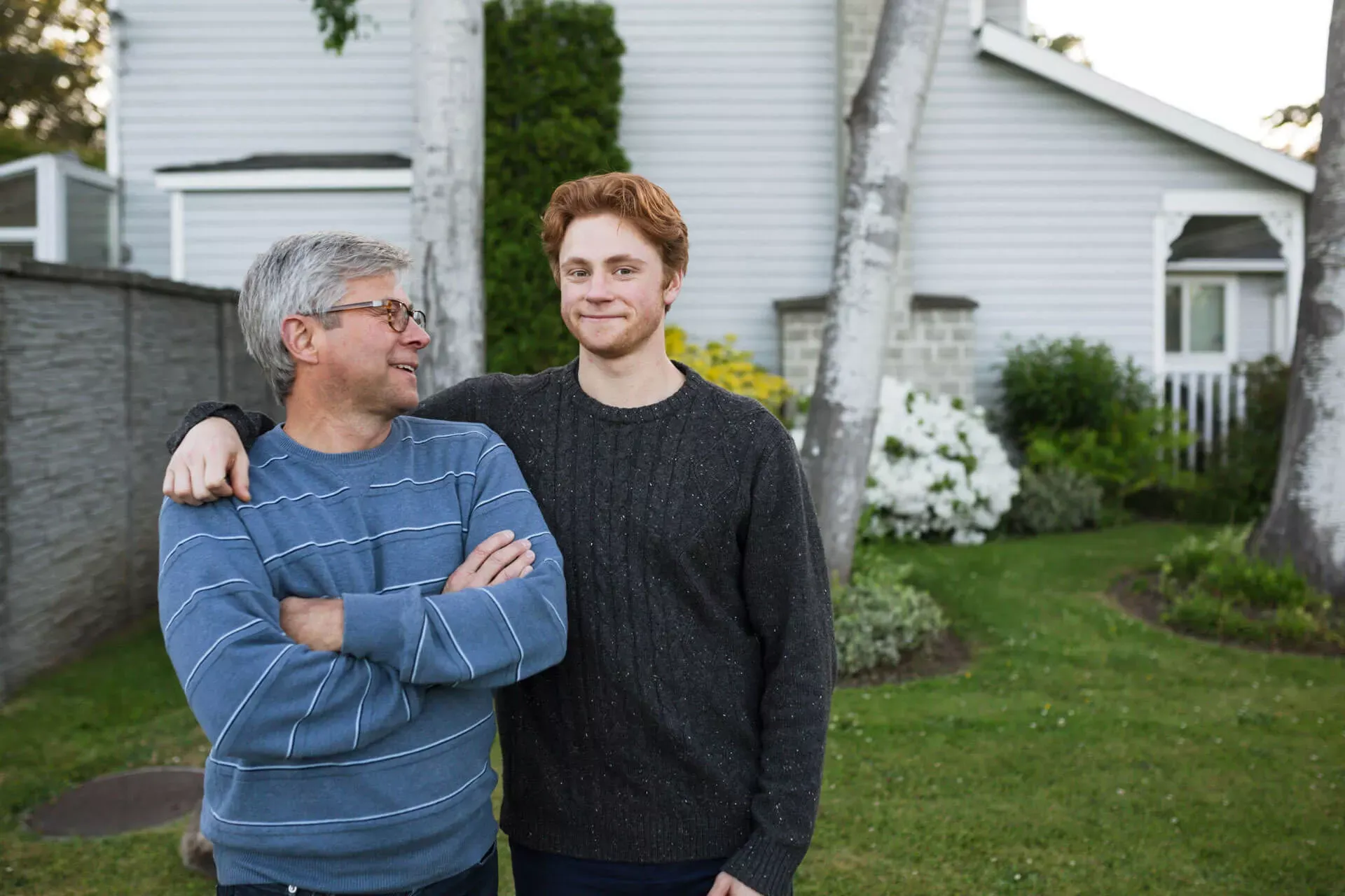 Vater und Sohn stehen im Garten vor dem Haus. Vater und Sohn stehen im Garten vor dem Haus.