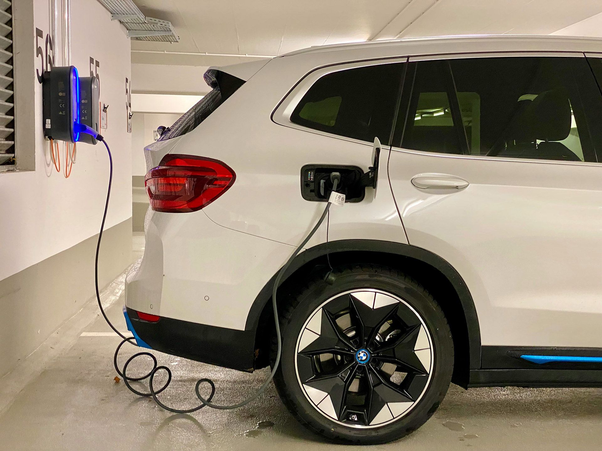 E-Auto lädt an Wallbox in Tiefgarage. E-Auto lädt an Wallbox in Tiefgarage.