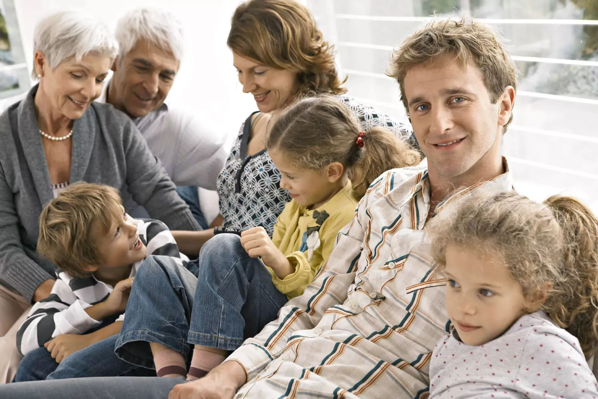 Familie mit Großeltern, Eltern und Kindern sitzt zusammen auf dem Sofa. Familie mit Großeltern, Eltern und Kindern sitzt zusammen auf dem Sofa.