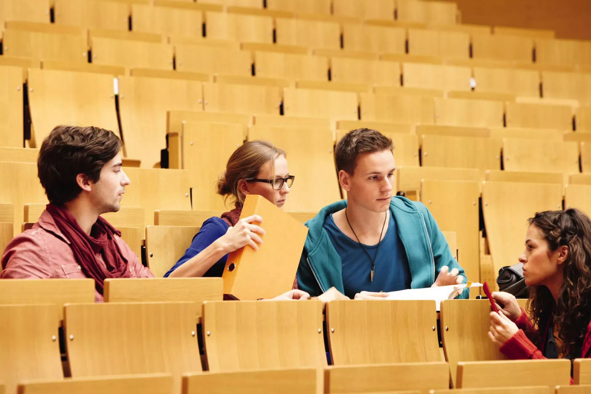 Studentinnen und Studenten unterhalten sich im Hörsaal. Studentinnen und Studenten unterhalten sich im Hörsaal.