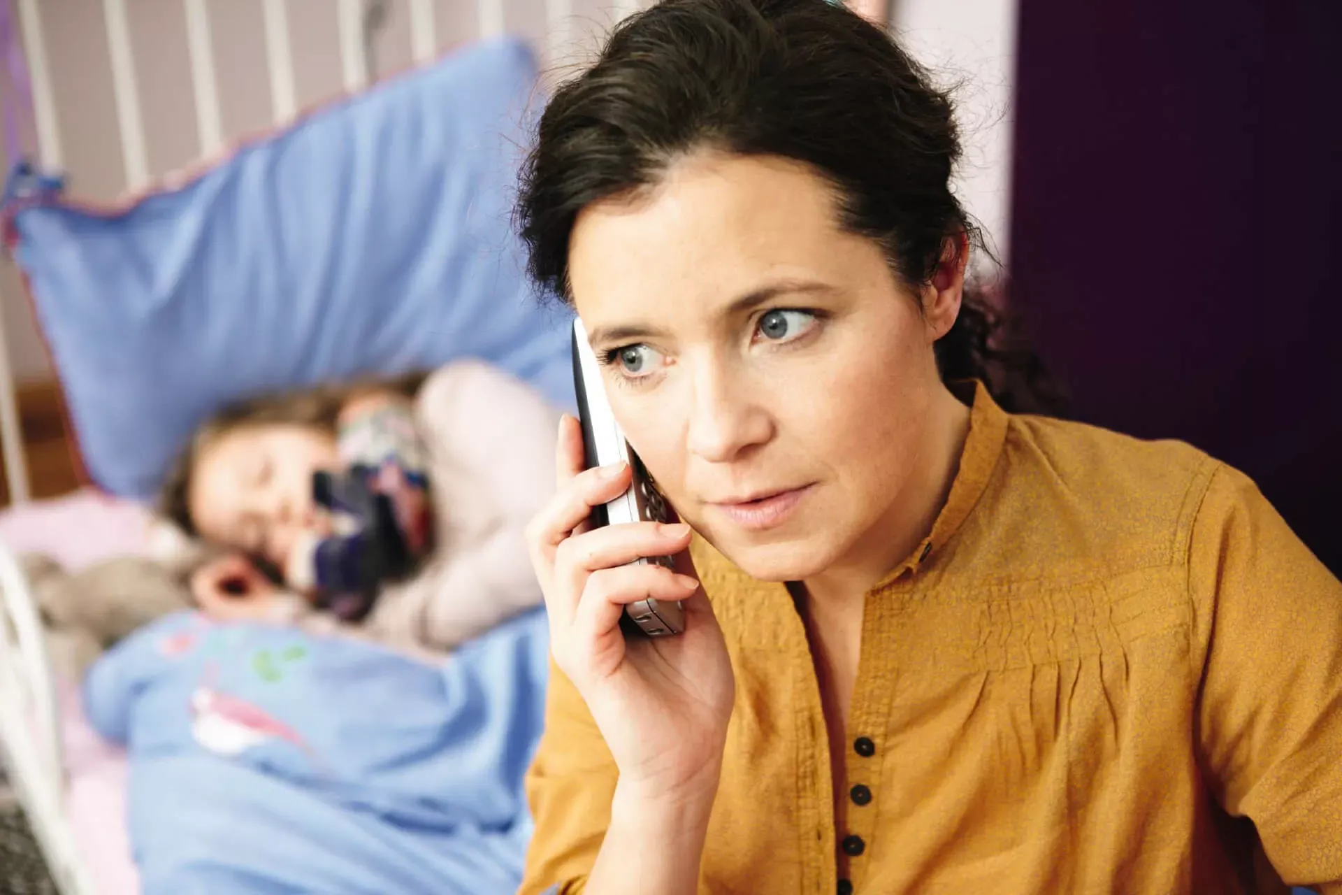 Mutter telefoniert, während Tochter im Hintergrund krank im Bett liegt. Mutter telefoniert, während Tochter im Hintergrund krank im Bett liegt.