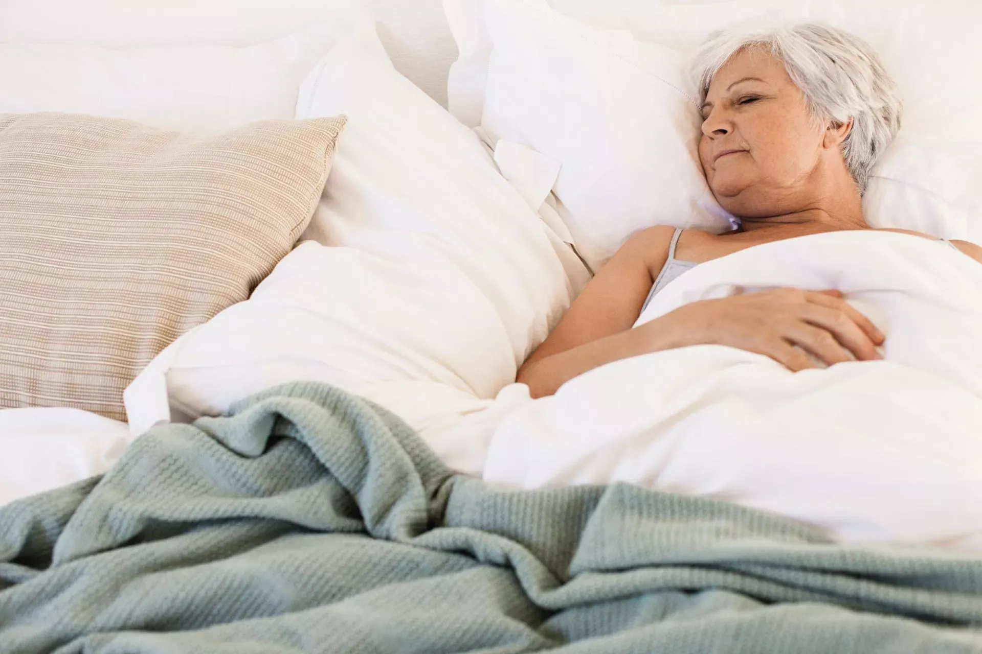 Seniorin liegt im Bett und schläft. Seniorin liegt im Bett und schläft.