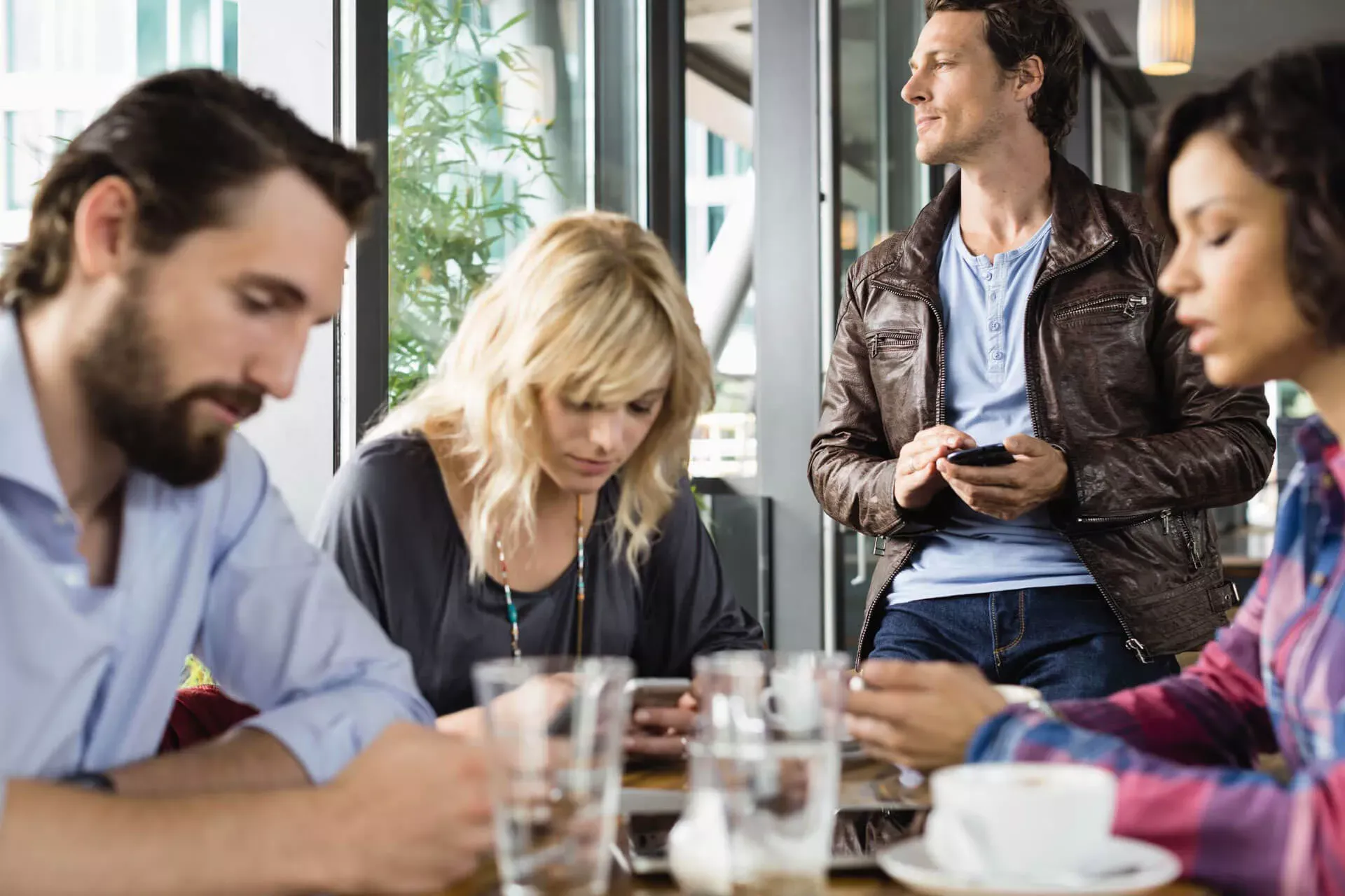 Gruppe von Menschen in einem Cafe, alle sind mit ihrem Smartphone beschäftigt. Gruppe von Menschen in einem Cafe, alle sind mit ihrem Smartphone beschäftigt.